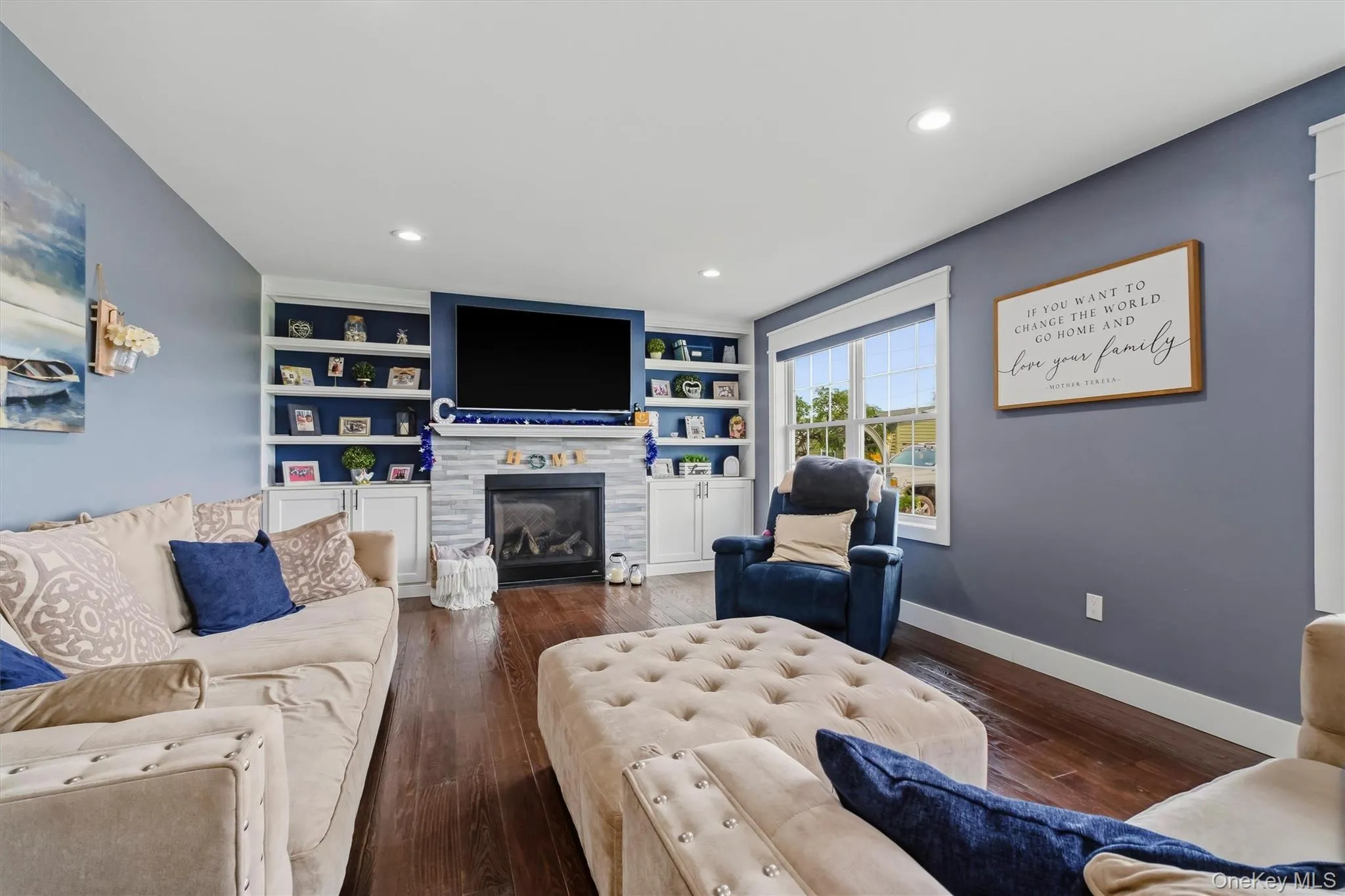 Hardwood-finish flooring, built-in shelving, stone-finish fireplace surround, recessed lighting, and large windows Hardwood-finish flooring, built-in shelving, stone-finish fireplace surround, recessed lighting, and large windows