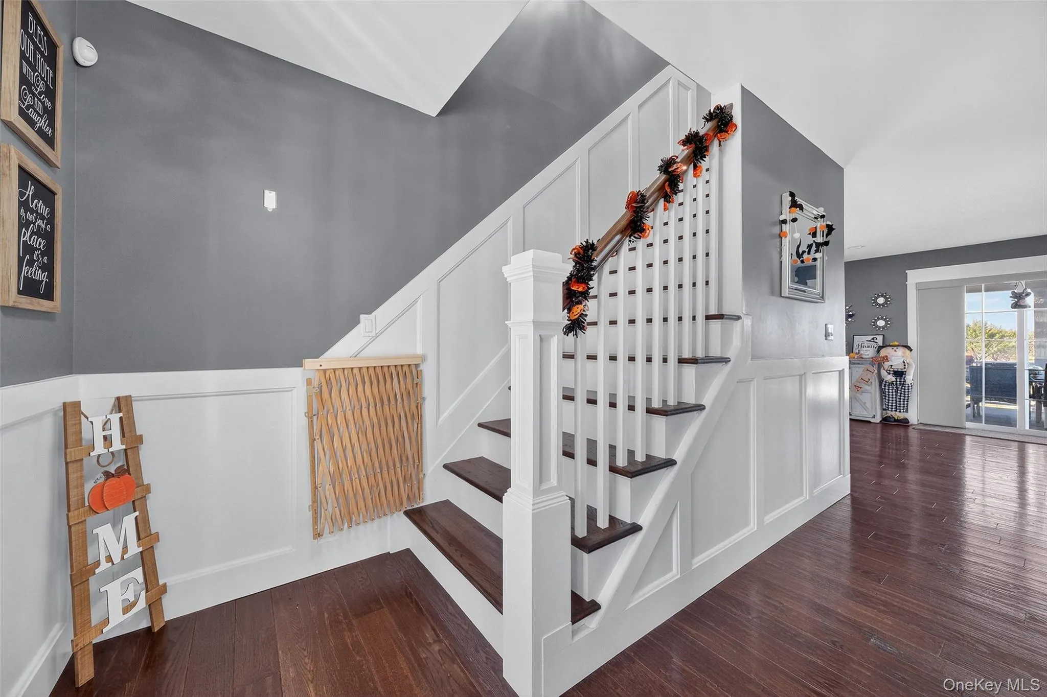 Hardwood flooring throughout, wainscoting detail, white painted staircase with dark wood-finish treads Hardwood flooring throughout, wainscoting detail, white painted staircase with dark wood-finish treads