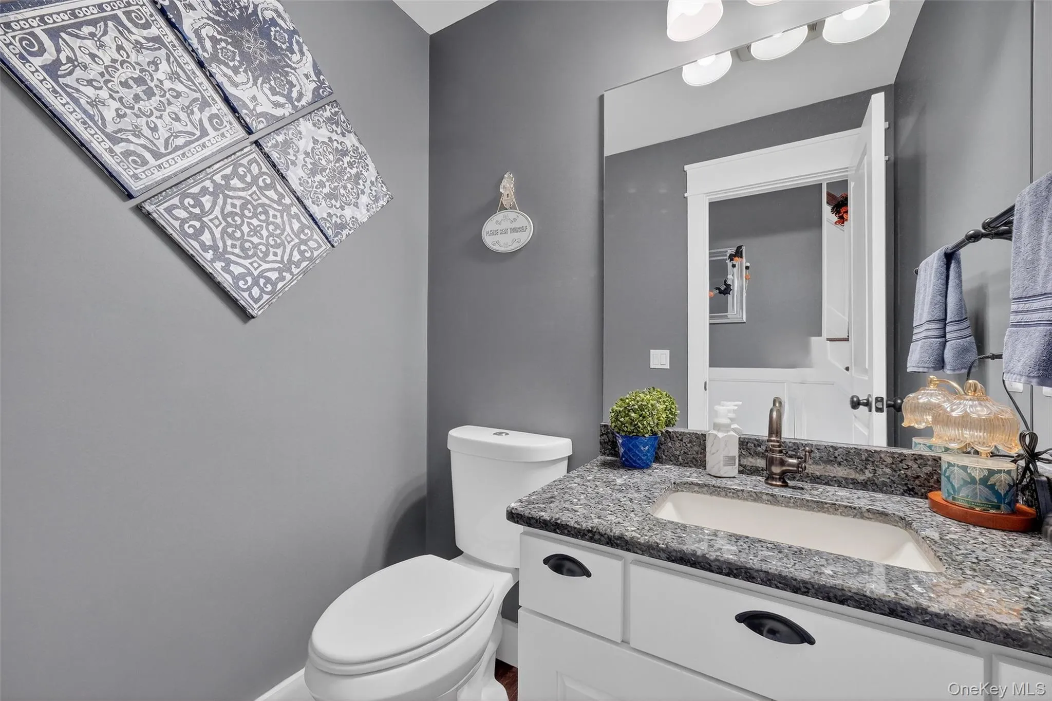 Vanity with stone countertop, undermount sink, and dark bronze-finish hardware Vanity with stone countertop, undermount sink, and dark bronze-finish hardware