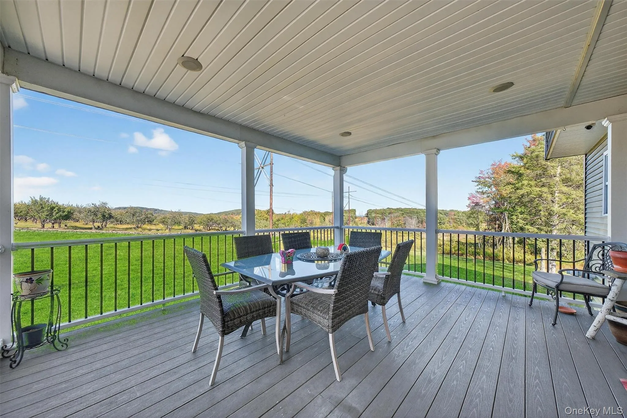 Covered deck featuring a wood-finish deck and black metal railing Covered deck featuring a wood-finish deck and black metal railing