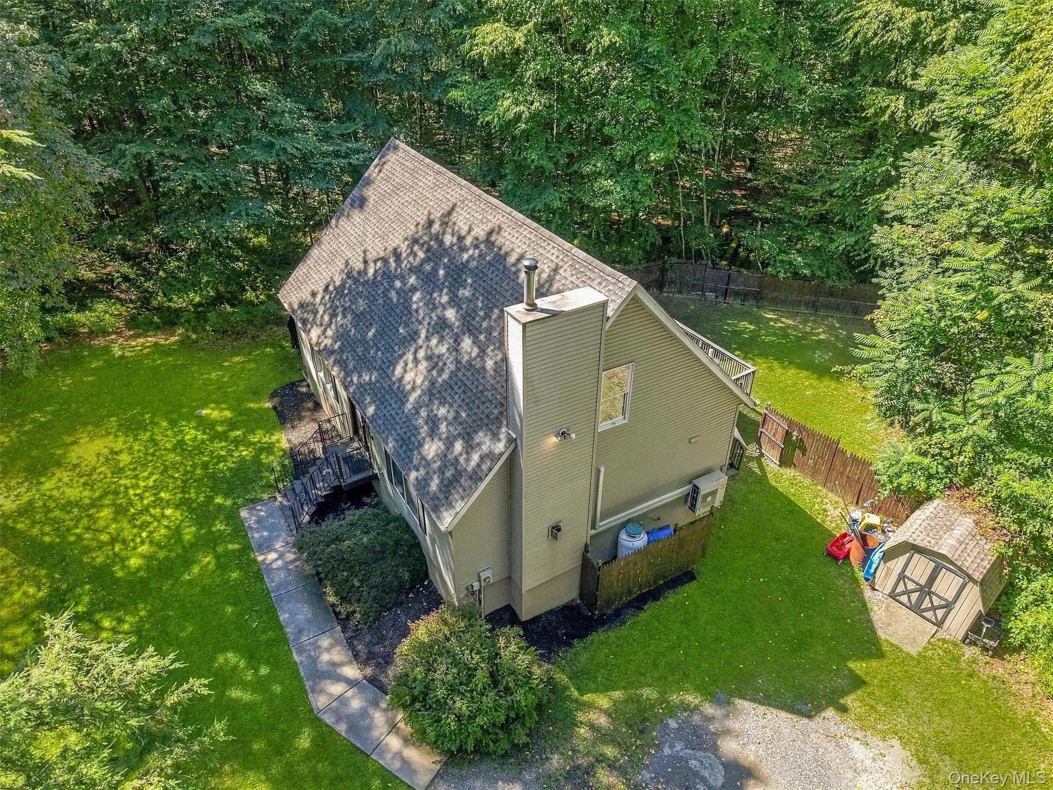 Gable roofline residence with a prominent chimney, surrounded by mature trees Gable roofline residence with a prominent chimney, surrounded by mature trees