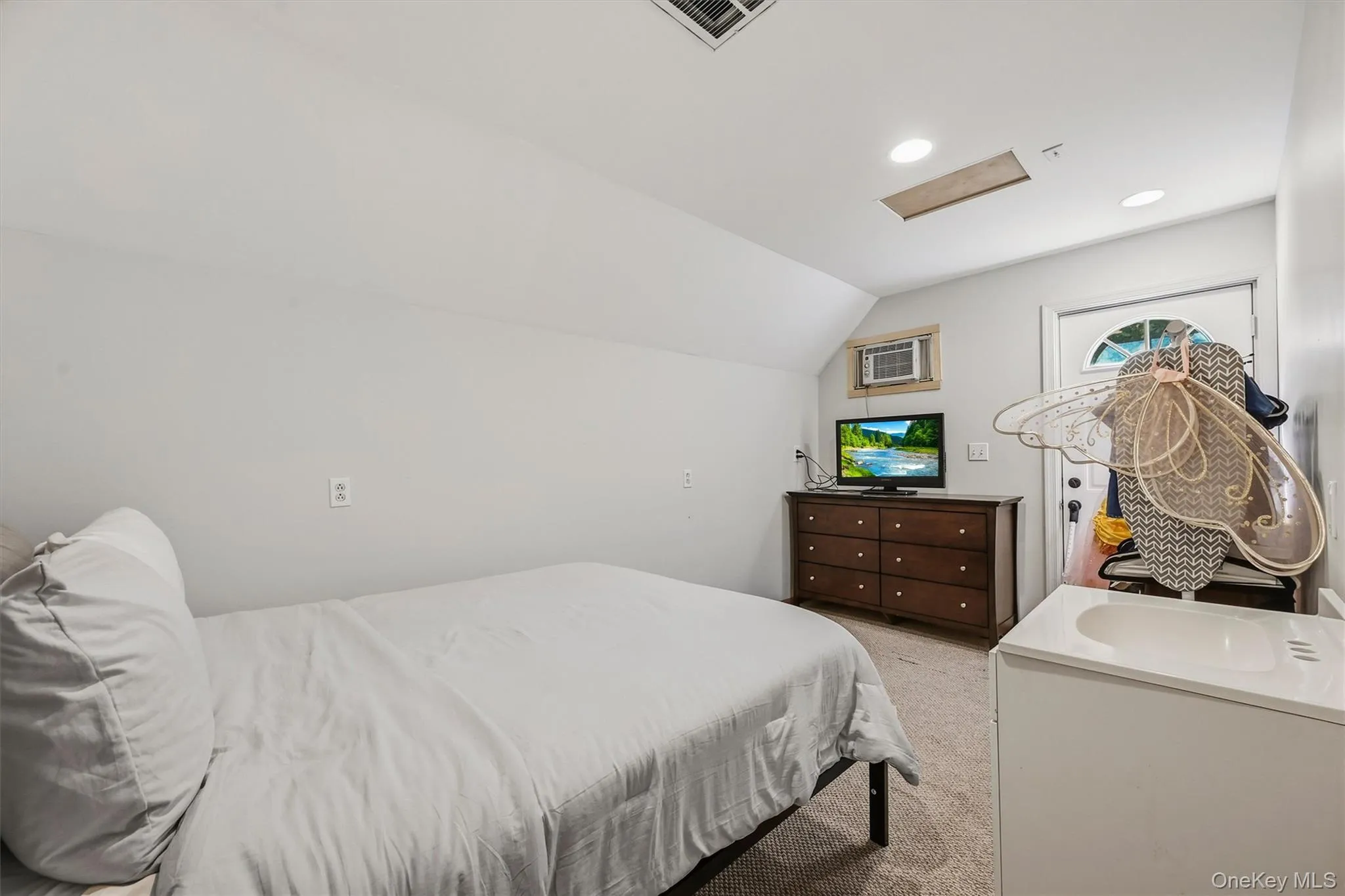 Sloped ceiling room featuring recessed lighting, a built-in window air conditioning unit, carpeted flooring, and a white vanity with an integrated sink Sloped ceiling room featuring recessed lighting, a built-in window air conditioning unit, carpeted flooring, and a white vanity with an integrated sink
