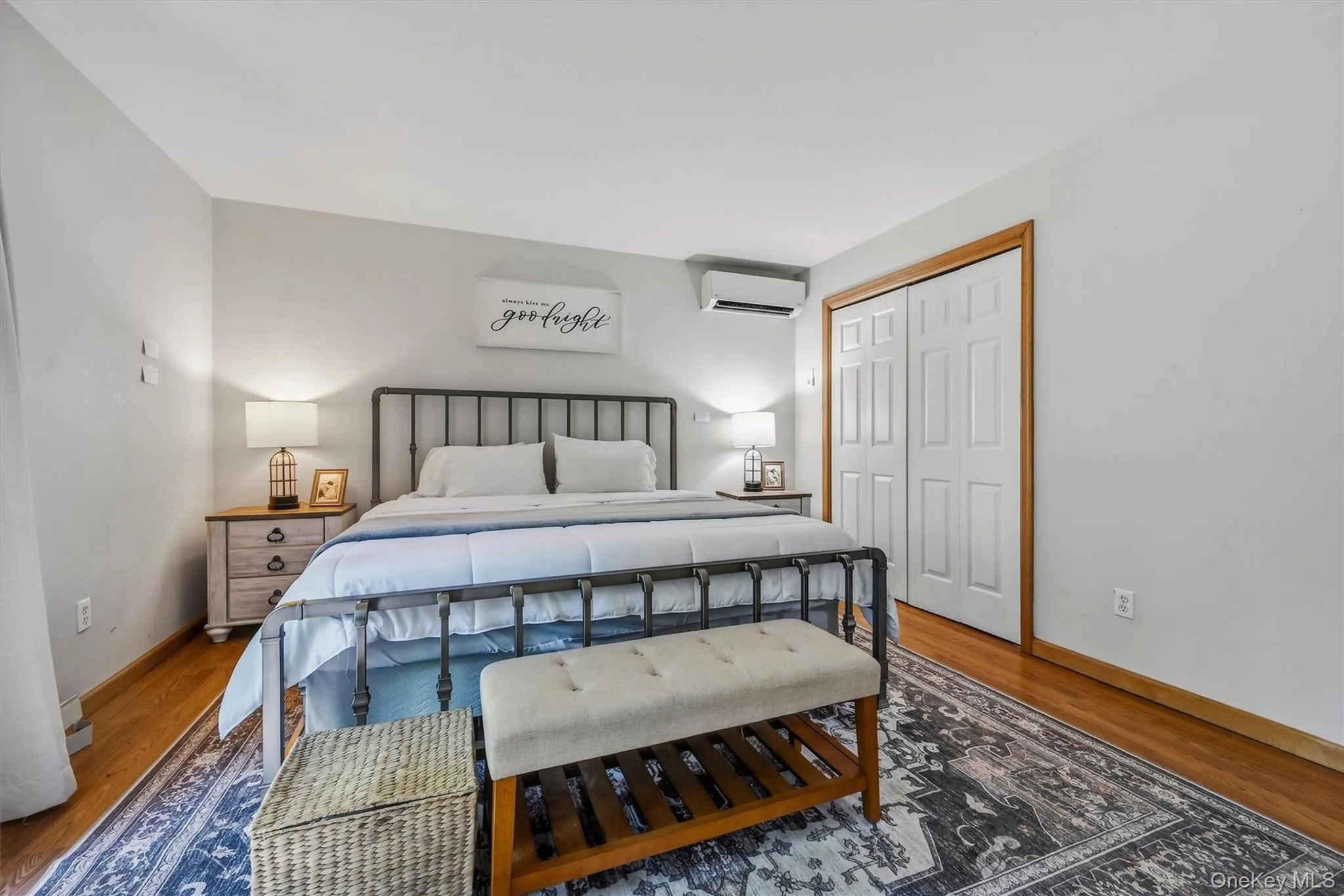 Wood-finish flooring with light-toned walls, white bi-fold closet doors, and wood trim details Wood-finish flooring with light-toned walls, white bi-fold closet doors, and wood trim details