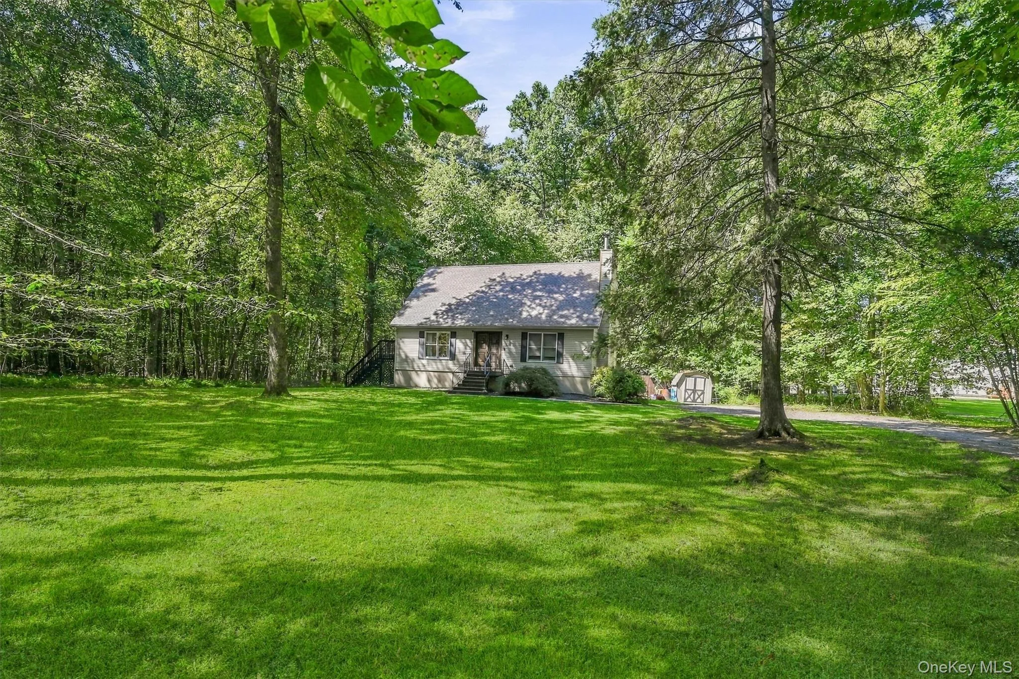 Expansive green lawn, mature trees, and a gravel drive leading to the residence Expansive green lawn, mature trees, and a gravel drive leading to the residence