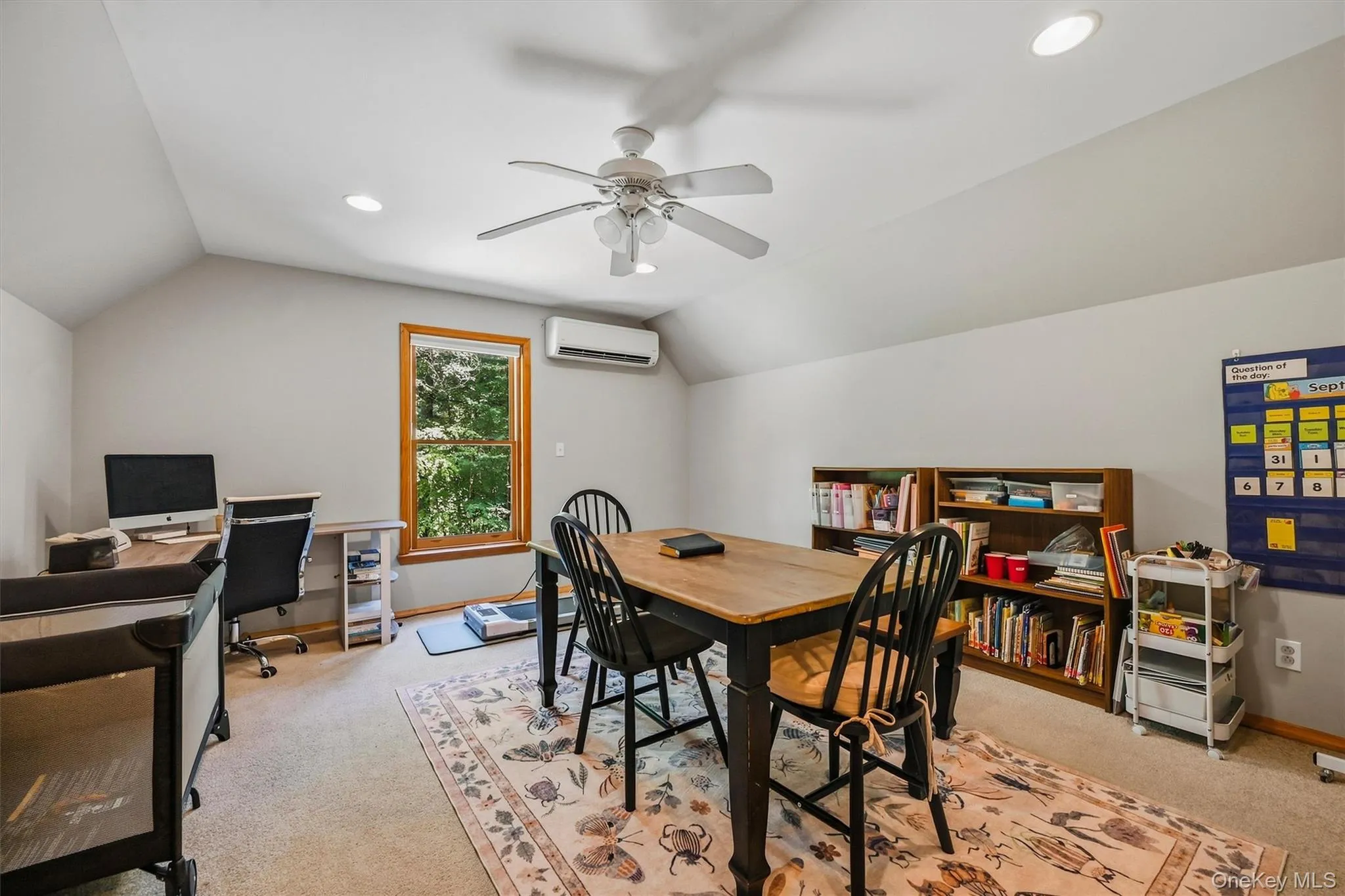 Sloped ceilings with recessed lighting, ceiling fan, window with wood trim, wall-mounted air conditioning unit, and built-in shelving Sloped ceilings with recessed lighting, ceiling fan, window with wood trim, wall-mounted air conditioning unit, and built-in shelving