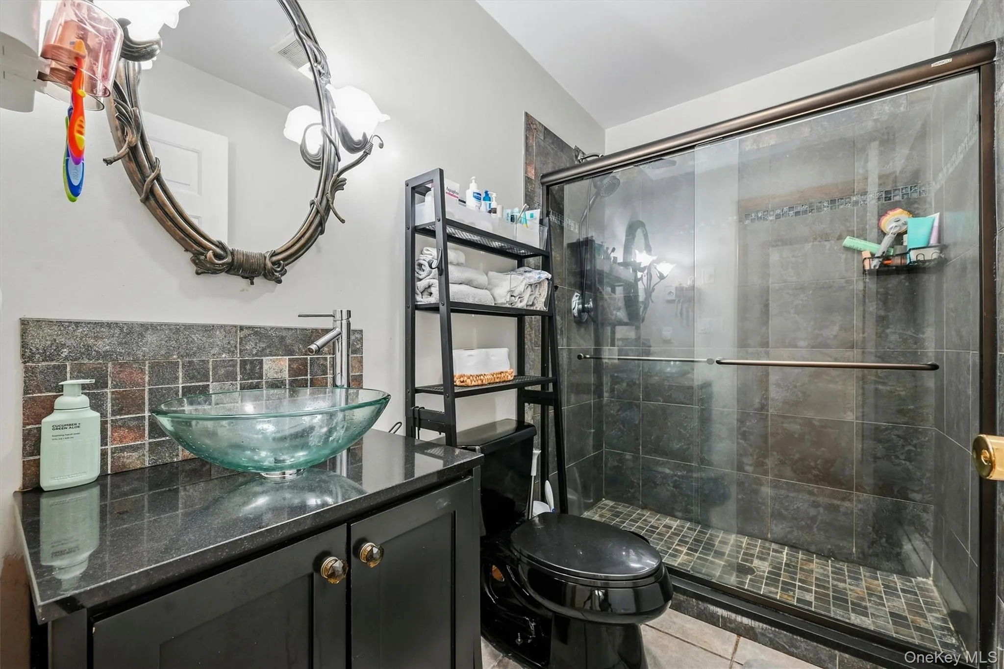 Glass vessel sink with a dark countertop and vanity Glass vessel sink with a dark countertop and vanity