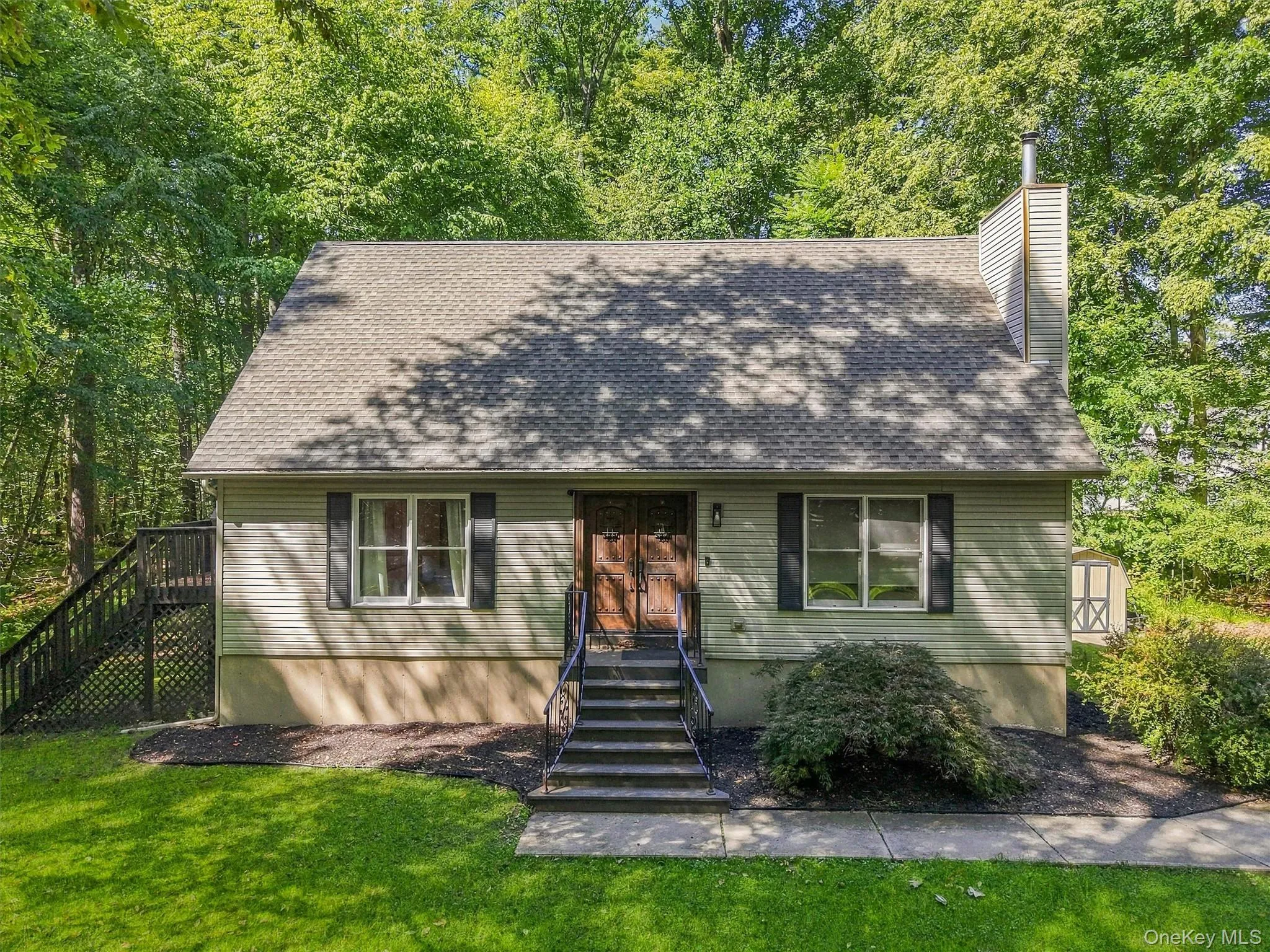 Exterior siding with a neutral finish, a dark entry door with decorative glass, and a gabled roof Exterior siding with a neutral finish, a dark entry door with decorative glass, and a gabled roof