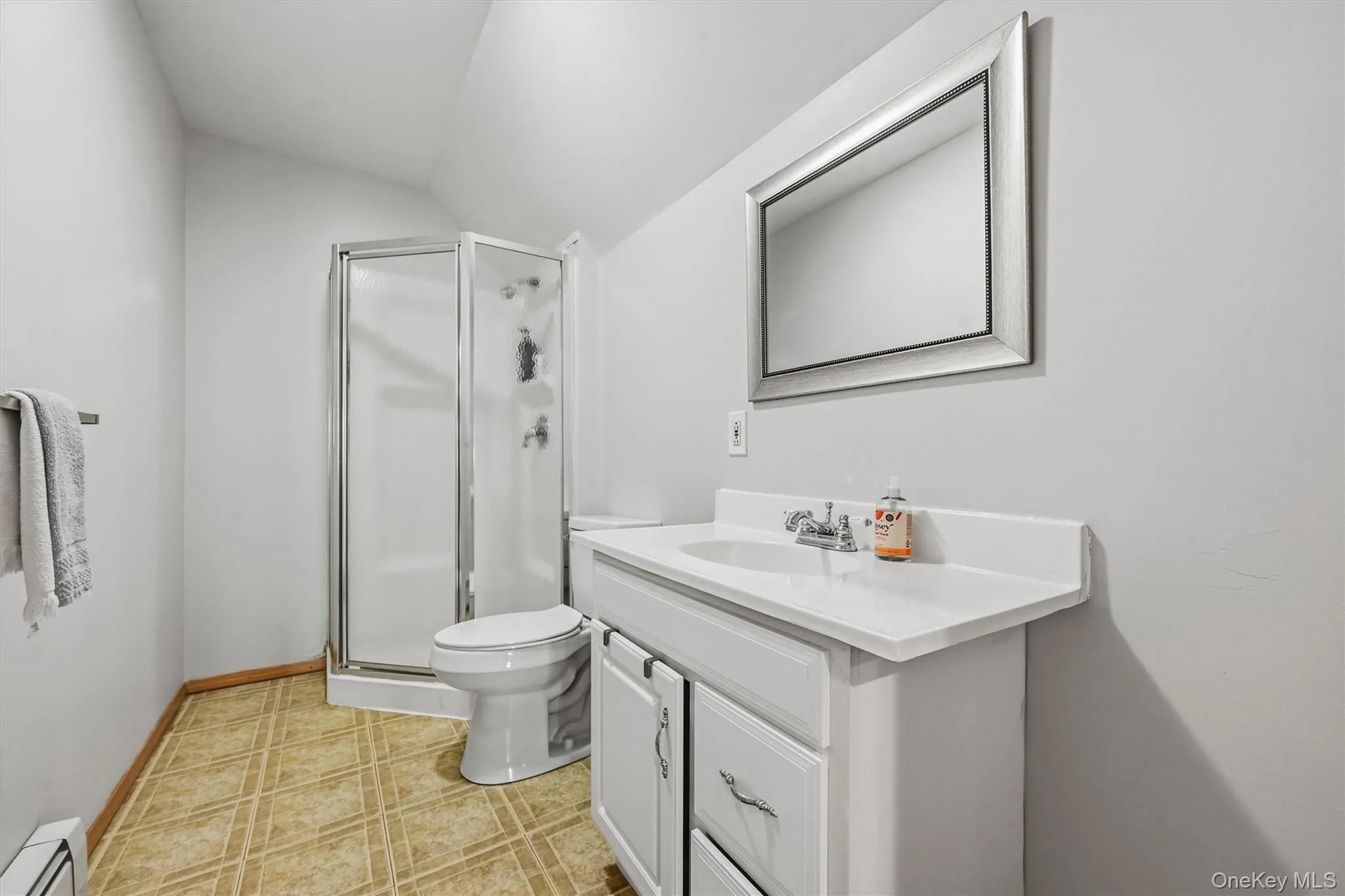 White vanity with a single basin sink, chrome faucet, and storage cabinetry White vanity with a single basin sink, chrome faucet, and storage cabinetry