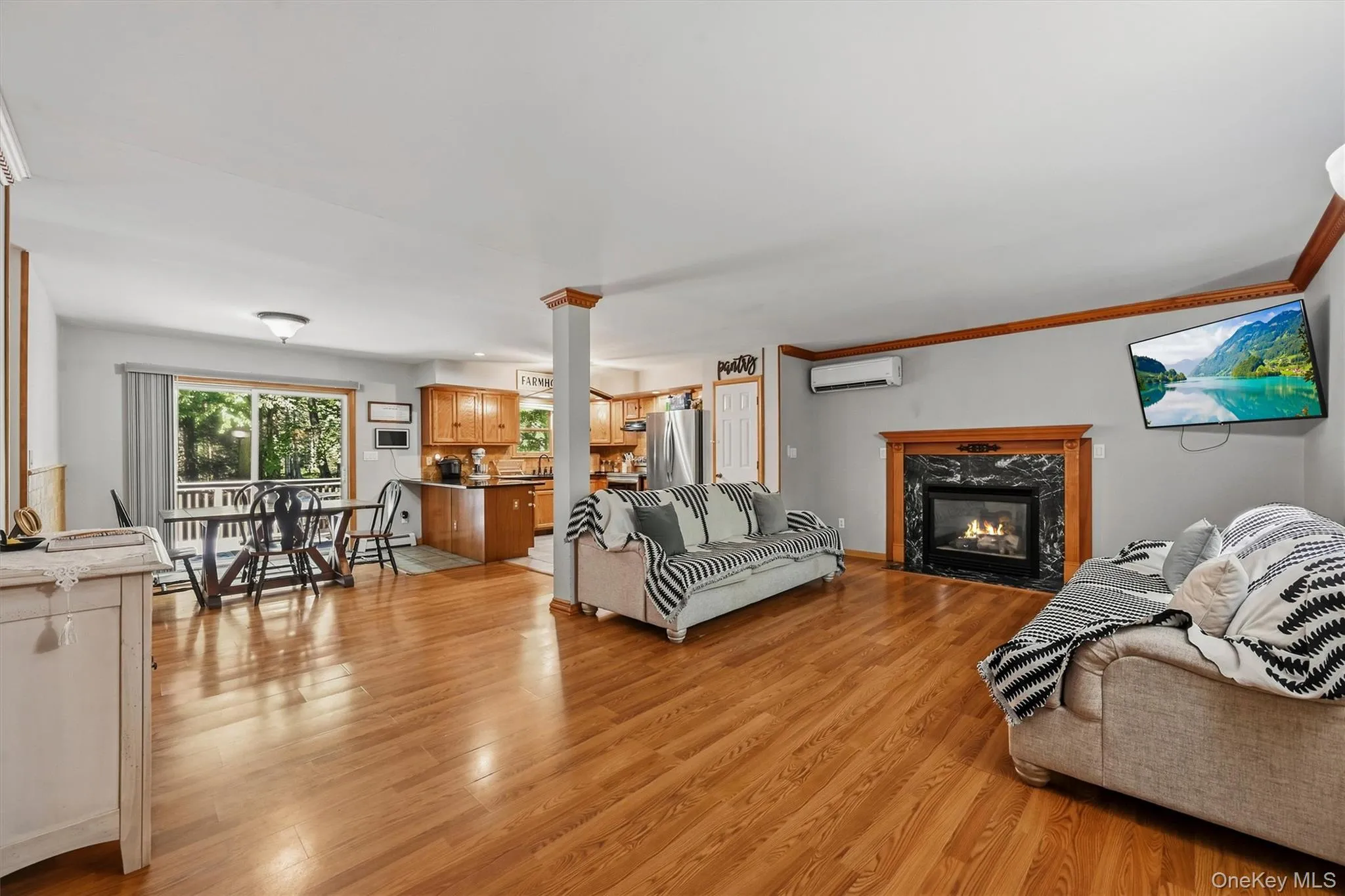 Hardwood flooring throughout, a gas fireplace with a stone surround, and wood-finish cabinetry Hardwood flooring throughout, a gas fireplace with a stone surround, and wood-finish cabinetry