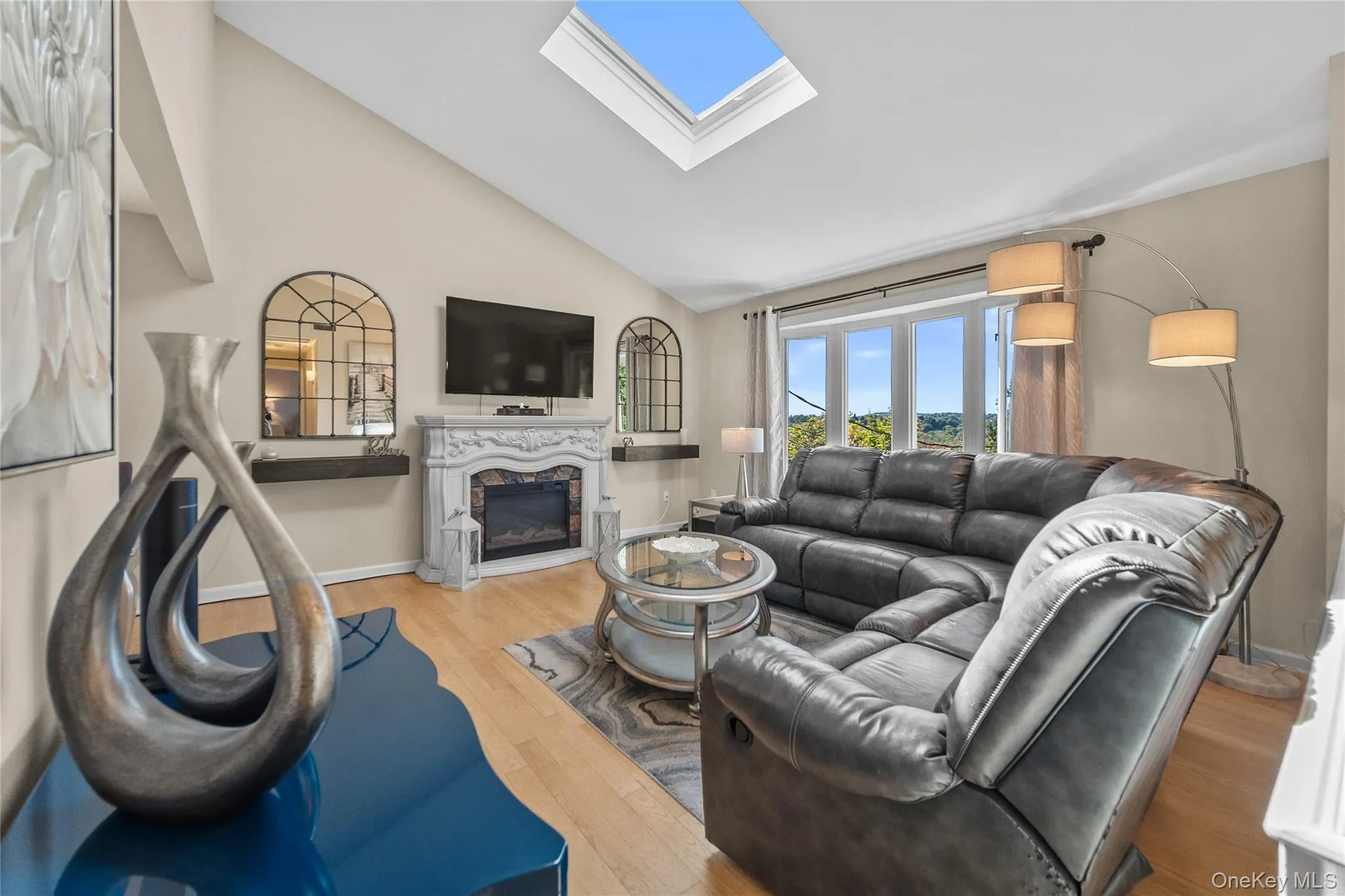 Living room with vaulted ceiling and skylight. Living room with vaulted ceiling and skylight.
