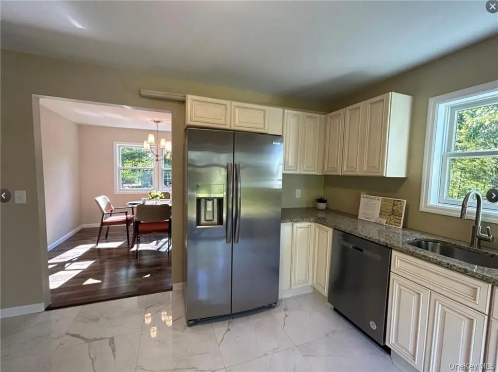 Kitchen featuring dark stone countertops, a healthy amount of sunlight, appliances with stainless steel finishes, and sink Kitchen featuring dark stone countertops, a healthy amount of sunlight, appliances with stainless steel finishes, and sink