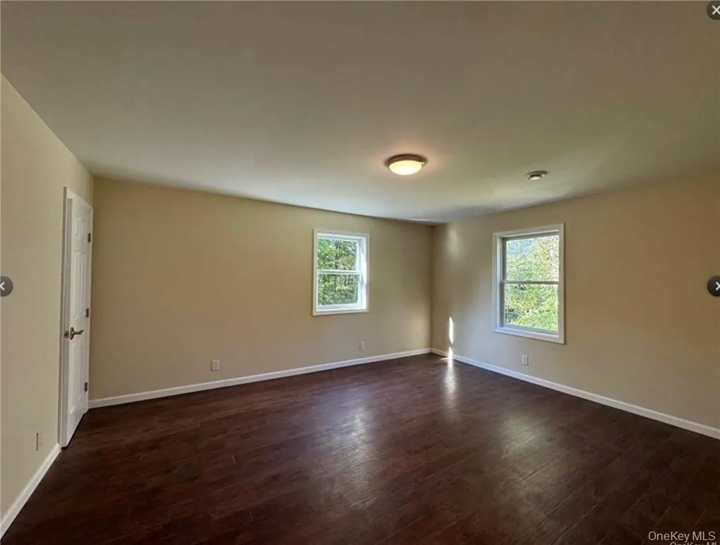 Master bedroom featuring dark hardwood / wood-style flooring and plenty of natural light Master bedroom featuring dark hardwood / wood-style flooring and plenty of natural light