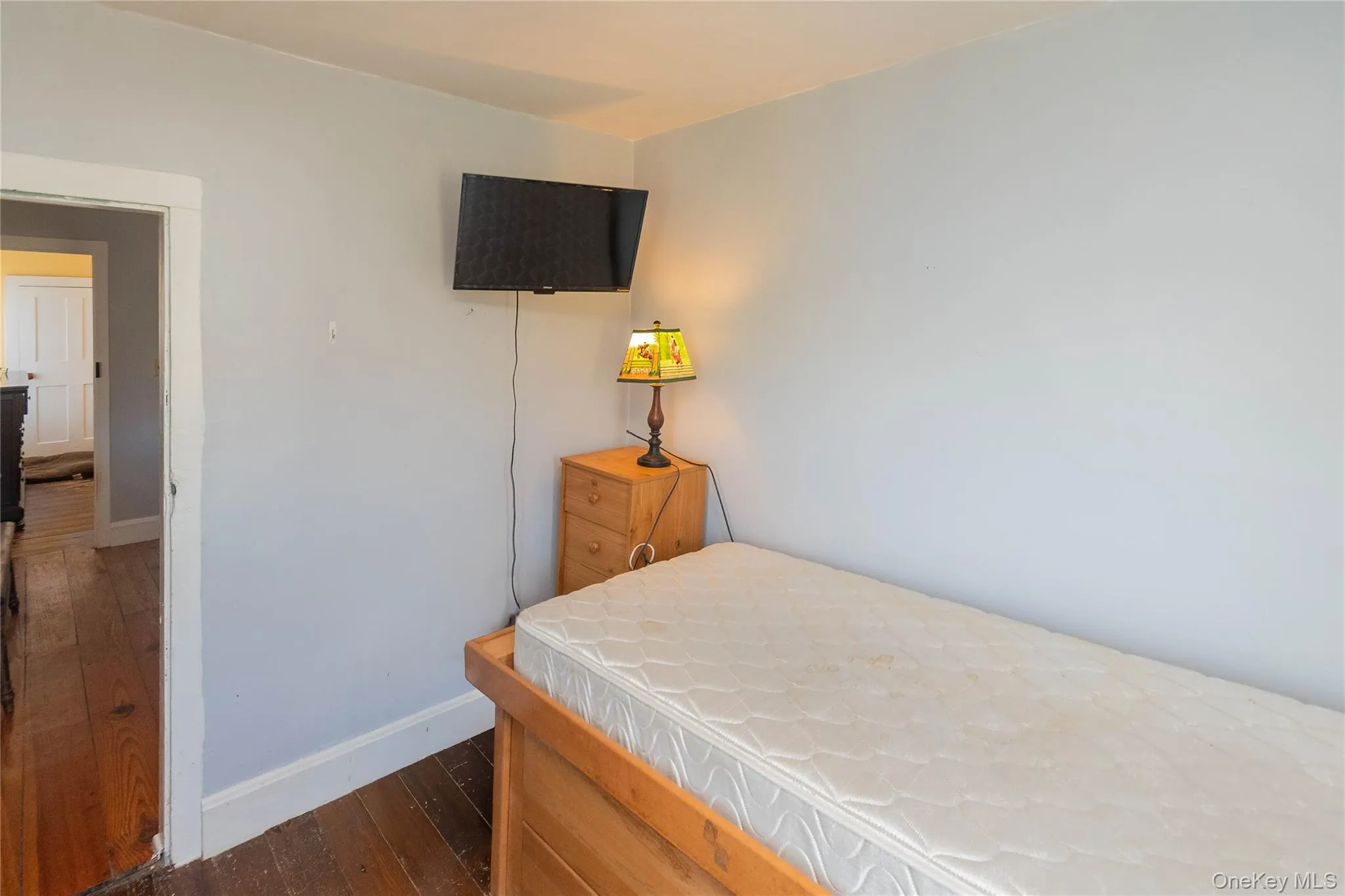 Bedroom with dark wood-style floors and baseboards Bedroom with dark wood-style floors and baseboards