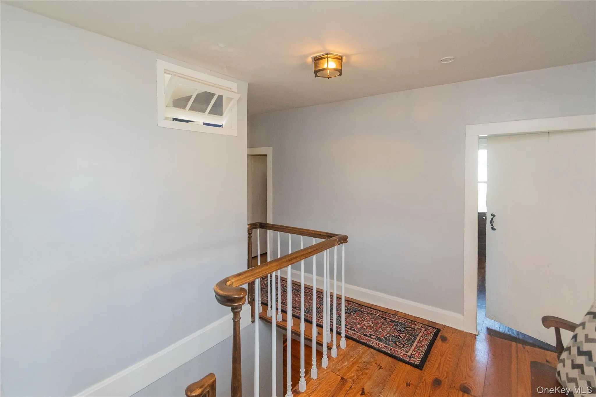 Corridor featuring an upstairs landing and hardwood / wood-style flooring Corridor featuring an upstairs landing and hardwood / wood-style flooring