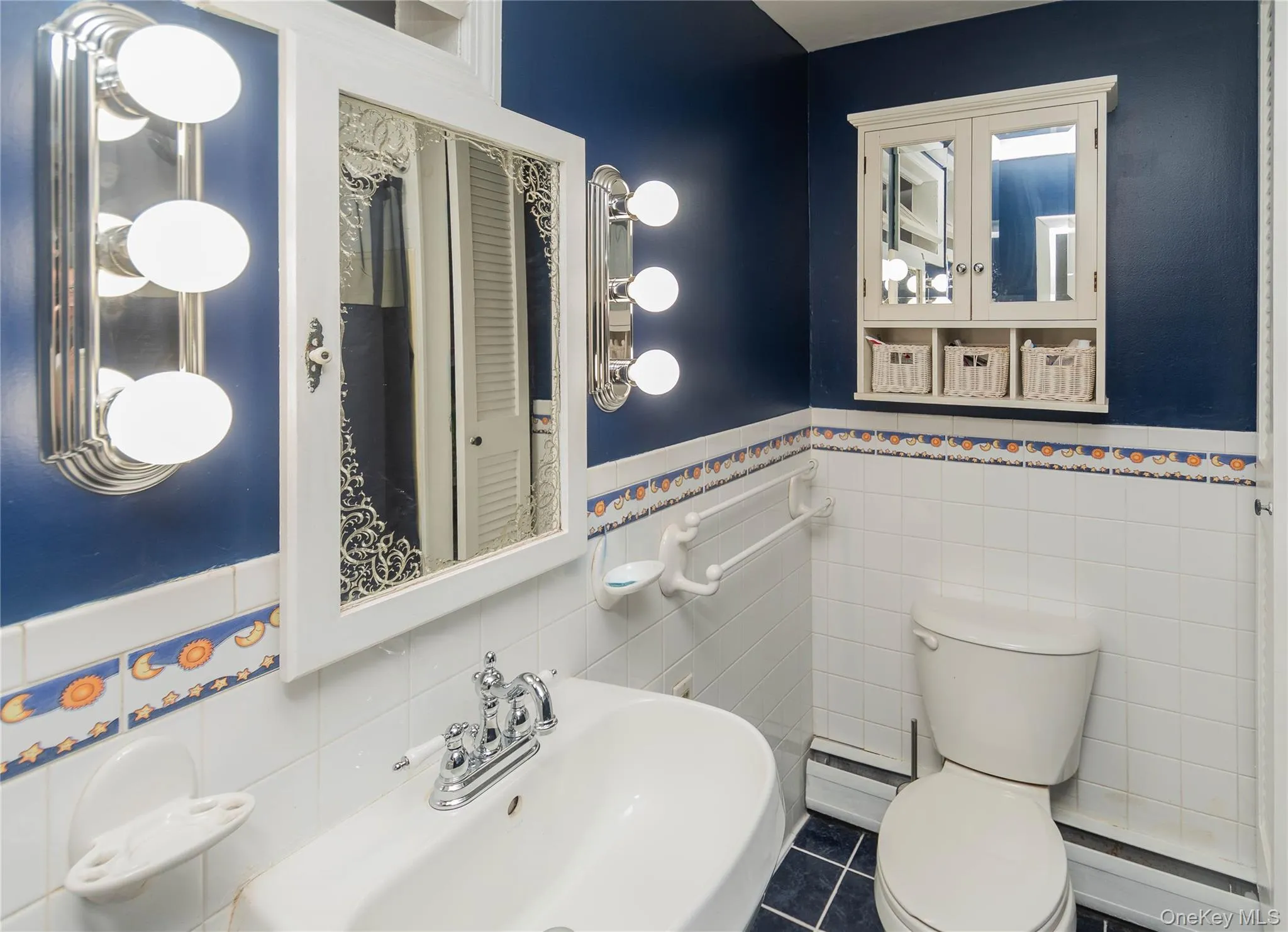 Half bathroom with tile walls, wainscoting, a baseboard heating unit, and tile patterned flooring Half bathroom with tile walls, wainscoting, a baseboard heating unit, and tile patterned flooring