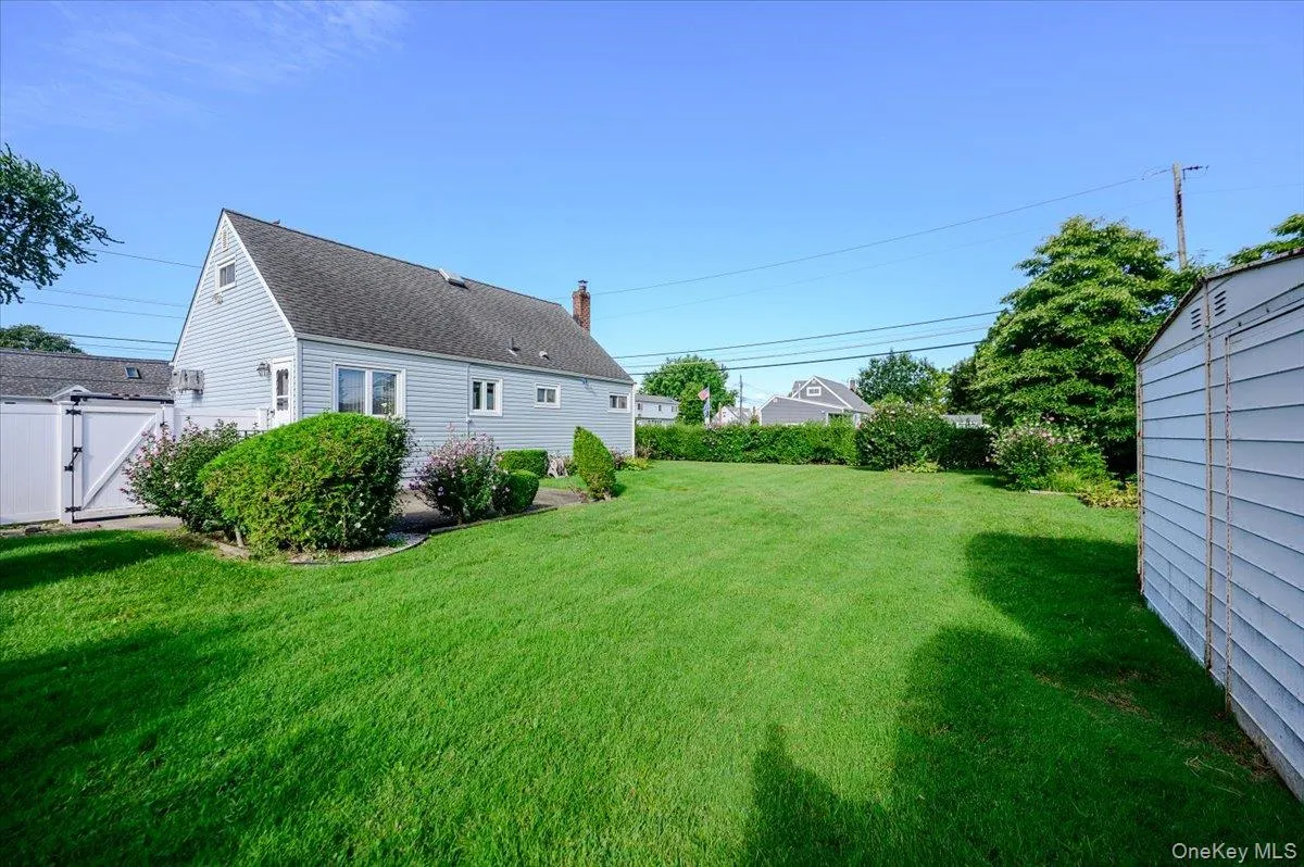 Expansive lawn with mature landscaping, a privacy fence, and a detached storage shed Expansive lawn with mature landscaping, a privacy fence, and a detached storage shed