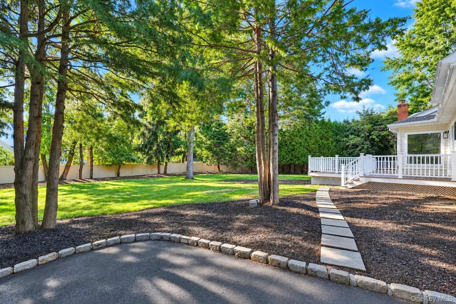Expansive green lawn surrounded by mature trees and privacy hedging Expansive green lawn surrounded by mature trees and privacy hedging
