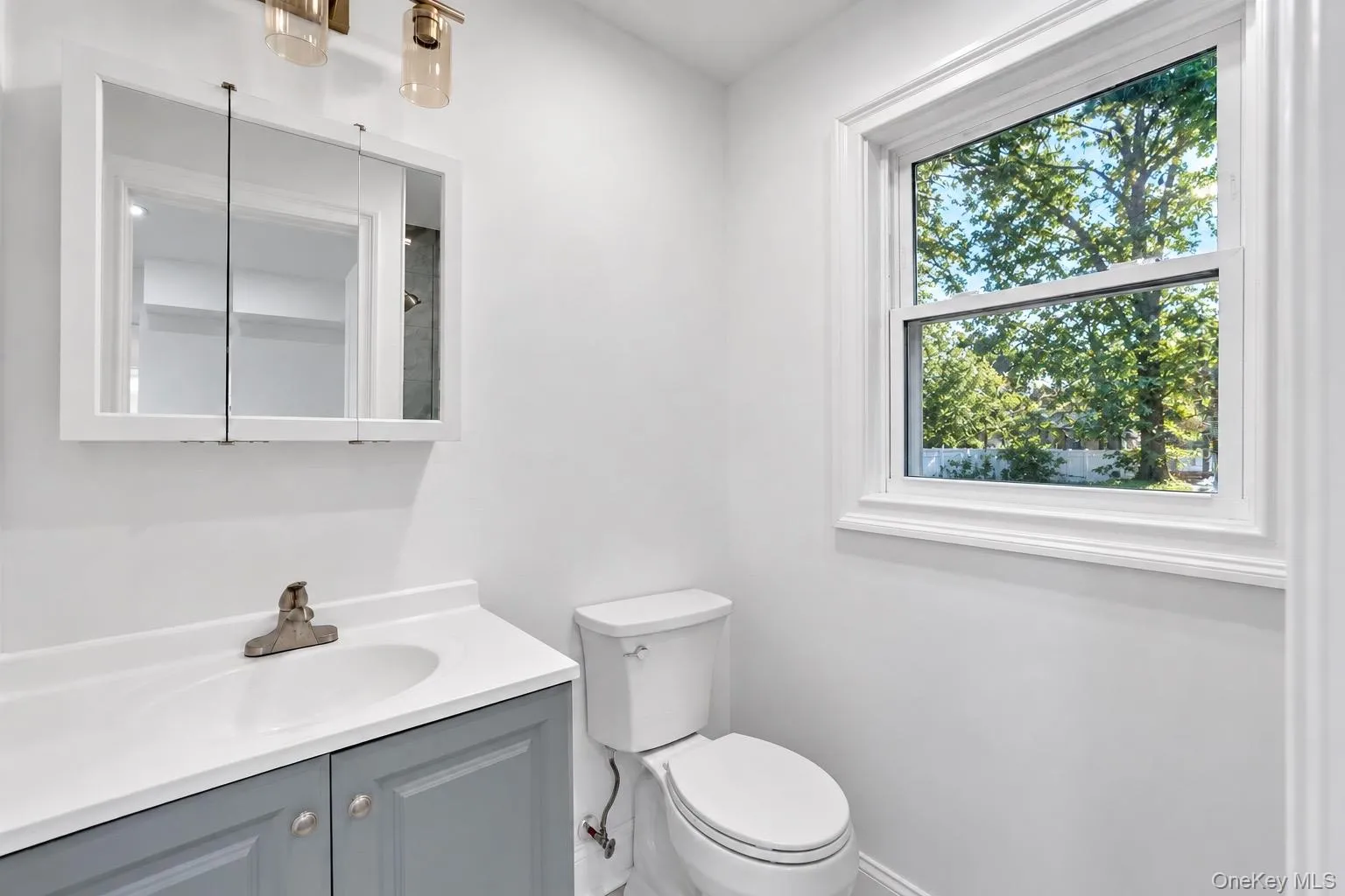 White wall-mounted medicine cabinet with a two-light vanity fixture White wall-mounted medicine cabinet with a two-light vanity fixture