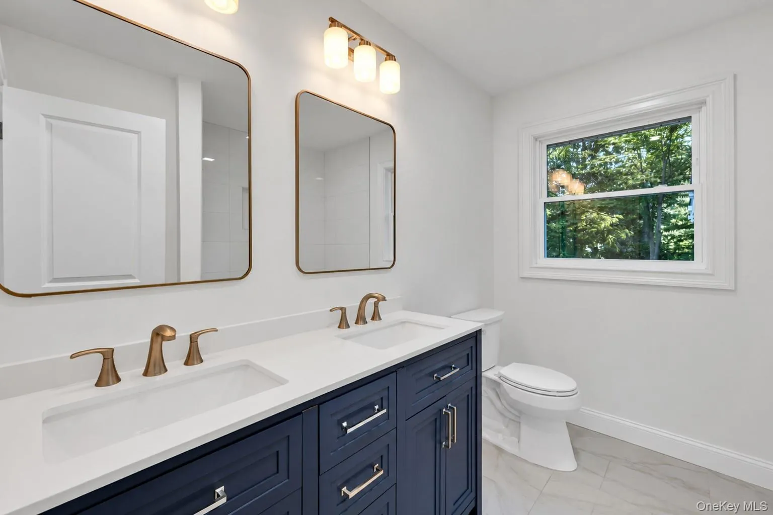 Dual vanity with bronze-finish fixtures, a white countertop, and a deep blue cabinet base Dual vanity with bronze-finish fixtures, a white countertop, and a deep blue cabinet base