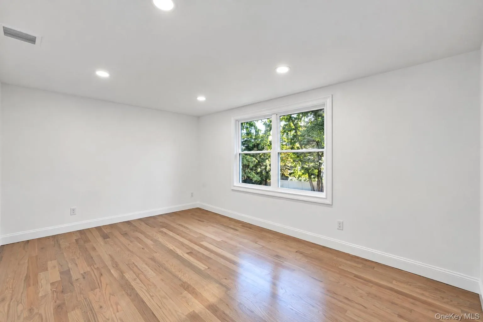 Recessed lighting illuminates wood-finish flooring with crisp white walls and trim Recessed lighting illuminates wood-finish flooring with crisp white walls and trim