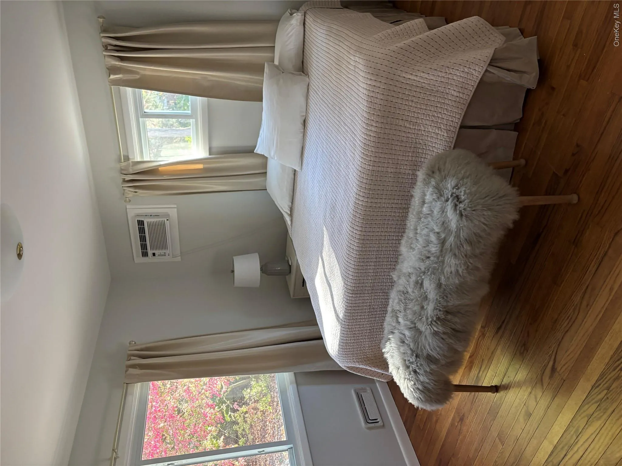 Bedroom with wood-type flooring and an AC wall unit Bedroom with wood-type flooring and an AC wall unit