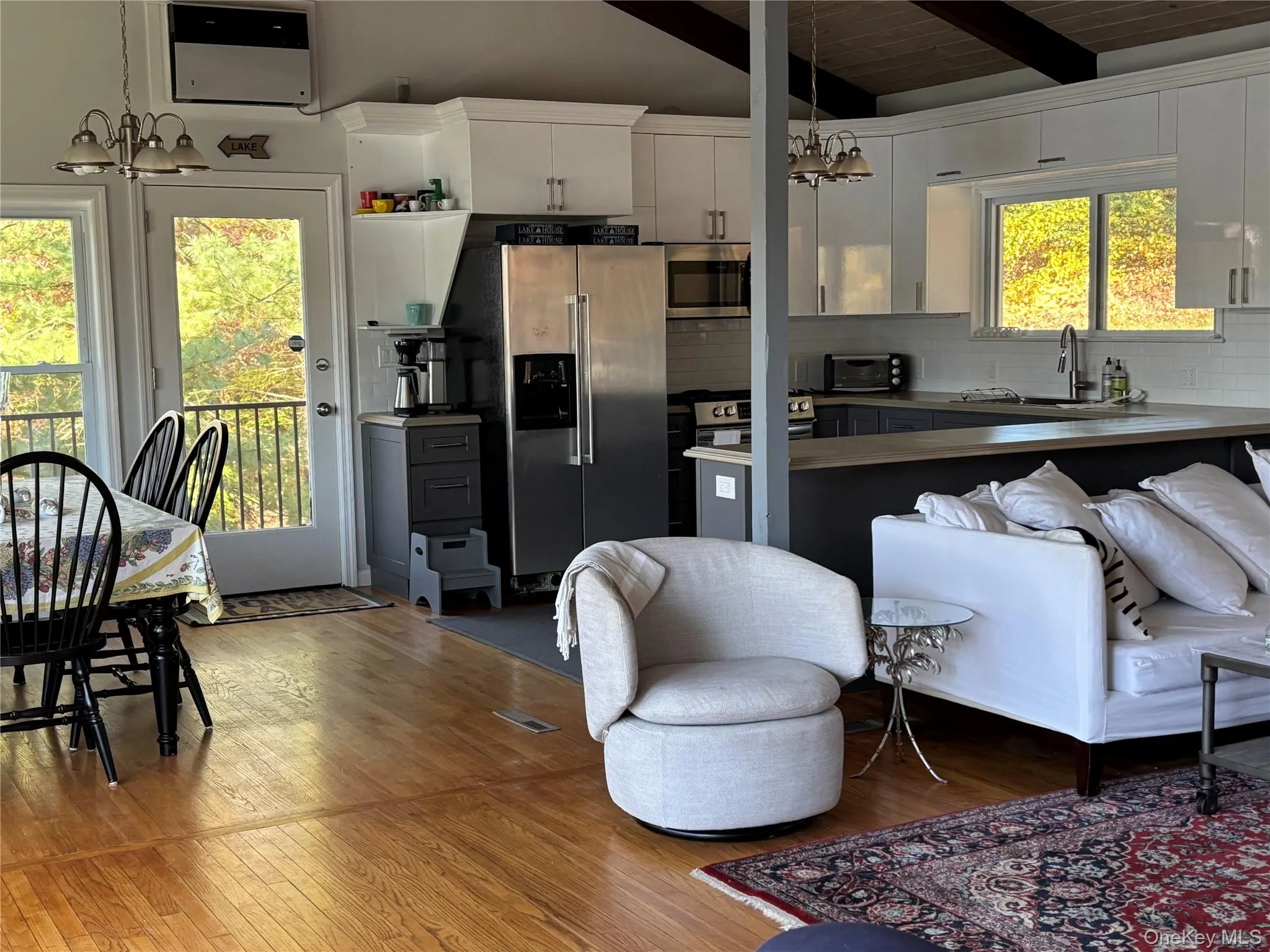 Kitchen featuring a chandelier, pendant lighting, stainless steel appliances, decorative backsplash, and wood ceiling Kitchen featuring a chandelier, pendant lighting, stainless steel appliances, decorative backsplash, and wood ceiling