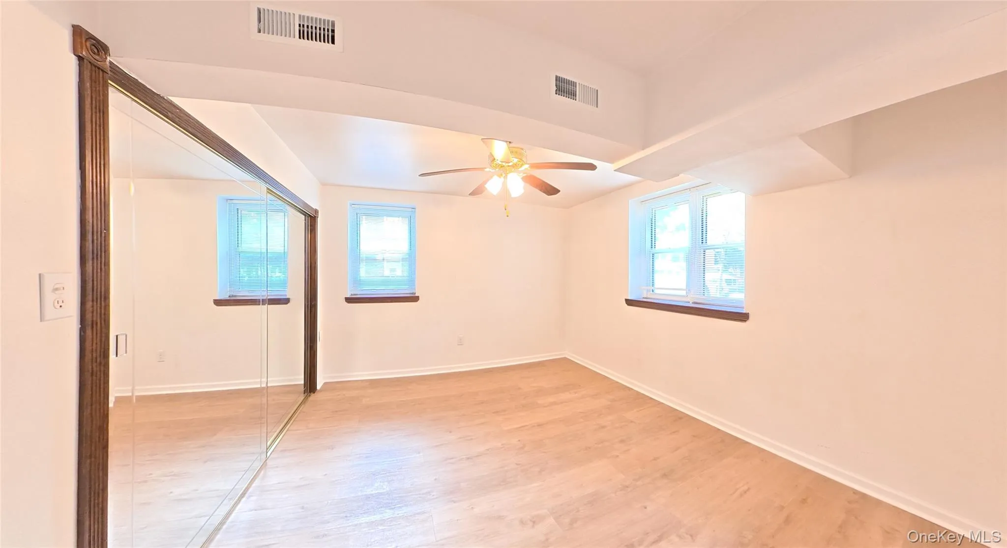 Wood-finish flooring, ceiling fan, mirrored closet doors, and built-in shelving Wood-finish flooring, ceiling fan, mirrored closet doors, and built-in shelving