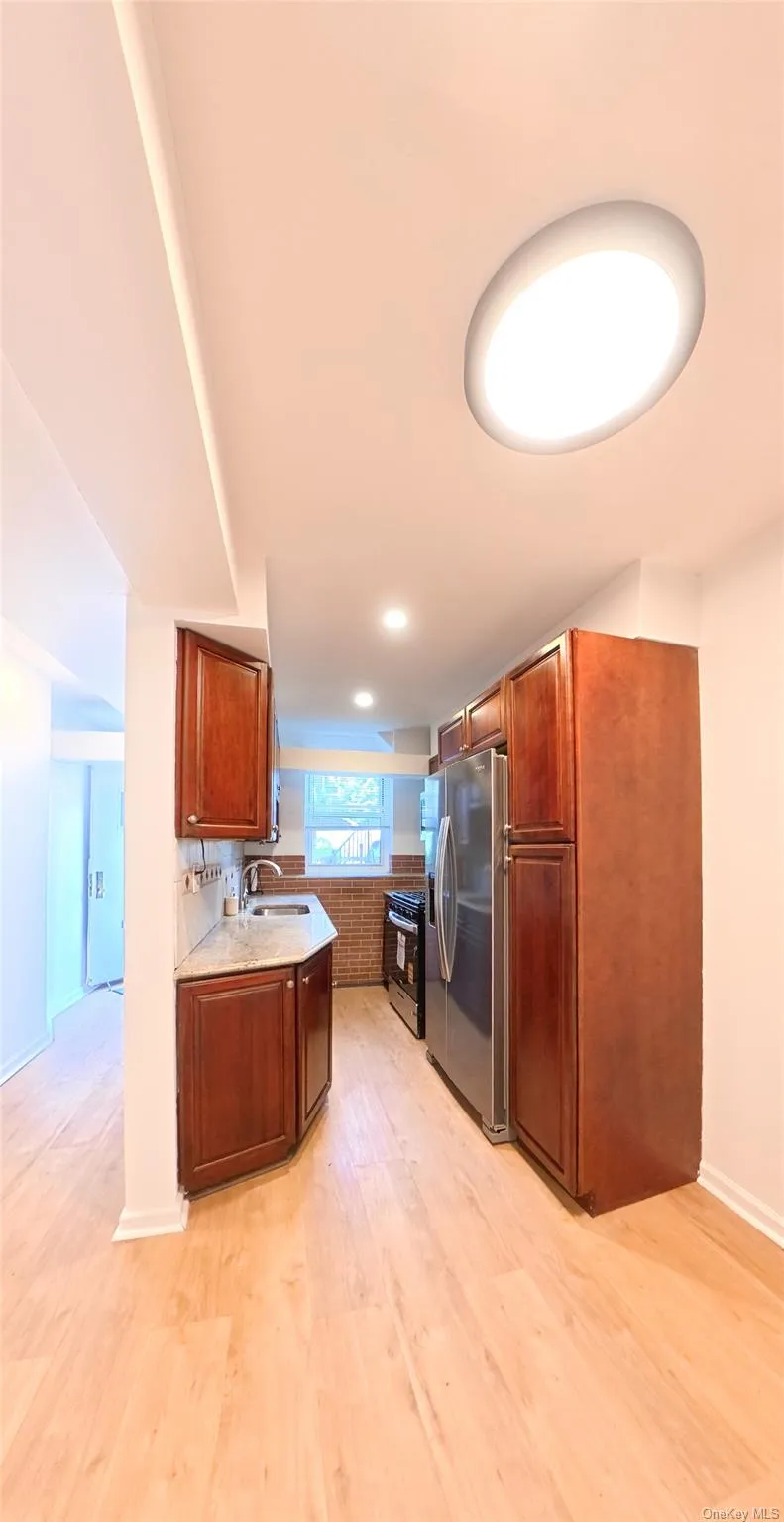 Kitchen featuring wood-finish flooring, recessed lighting, and ample cabinetry Kitchen featuring wood-finish flooring, recessed lighting, and ample cabinetry