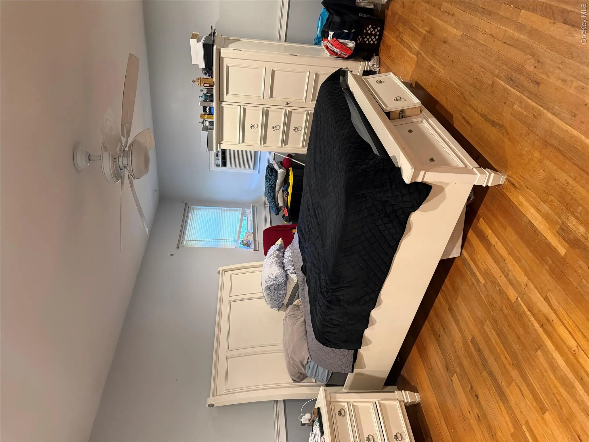 Over sized primary suite with his and hers closets. Hardwood flooring, recessed lighting, ceiling fan with light fixture, window with blinds Over sized primary suite with his and hers closets. Hardwood flooring, recessed lighting, ceiling fan with light fixture, window with blinds