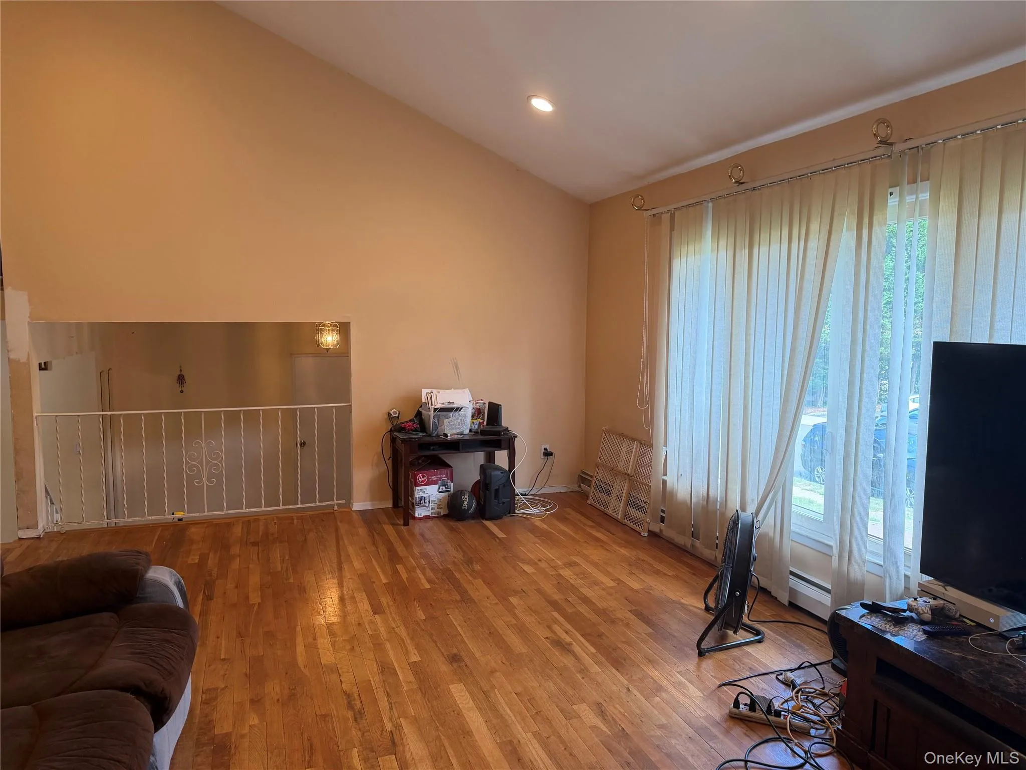 Vaulted ceiling with recessed lighting, wood-finish flooring, and large windows Vaulted ceiling with recessed lighting, wood-finish flooring, and large windows