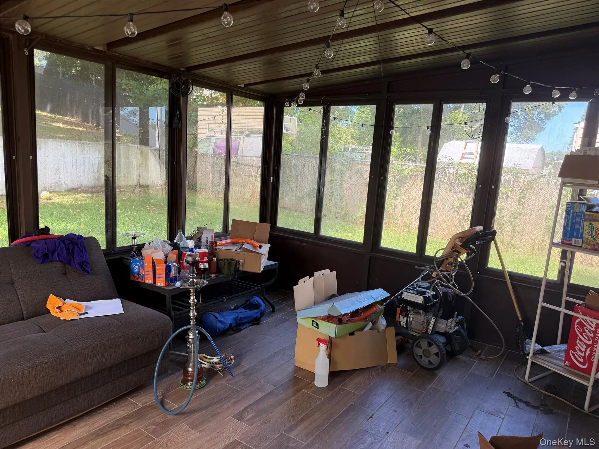 Screened enclosure with wood-finish flooring, multiple windows, and a slatted ceiling Screened enclosure with wood-finish flooring, multiple windows, and a slatted ceiling