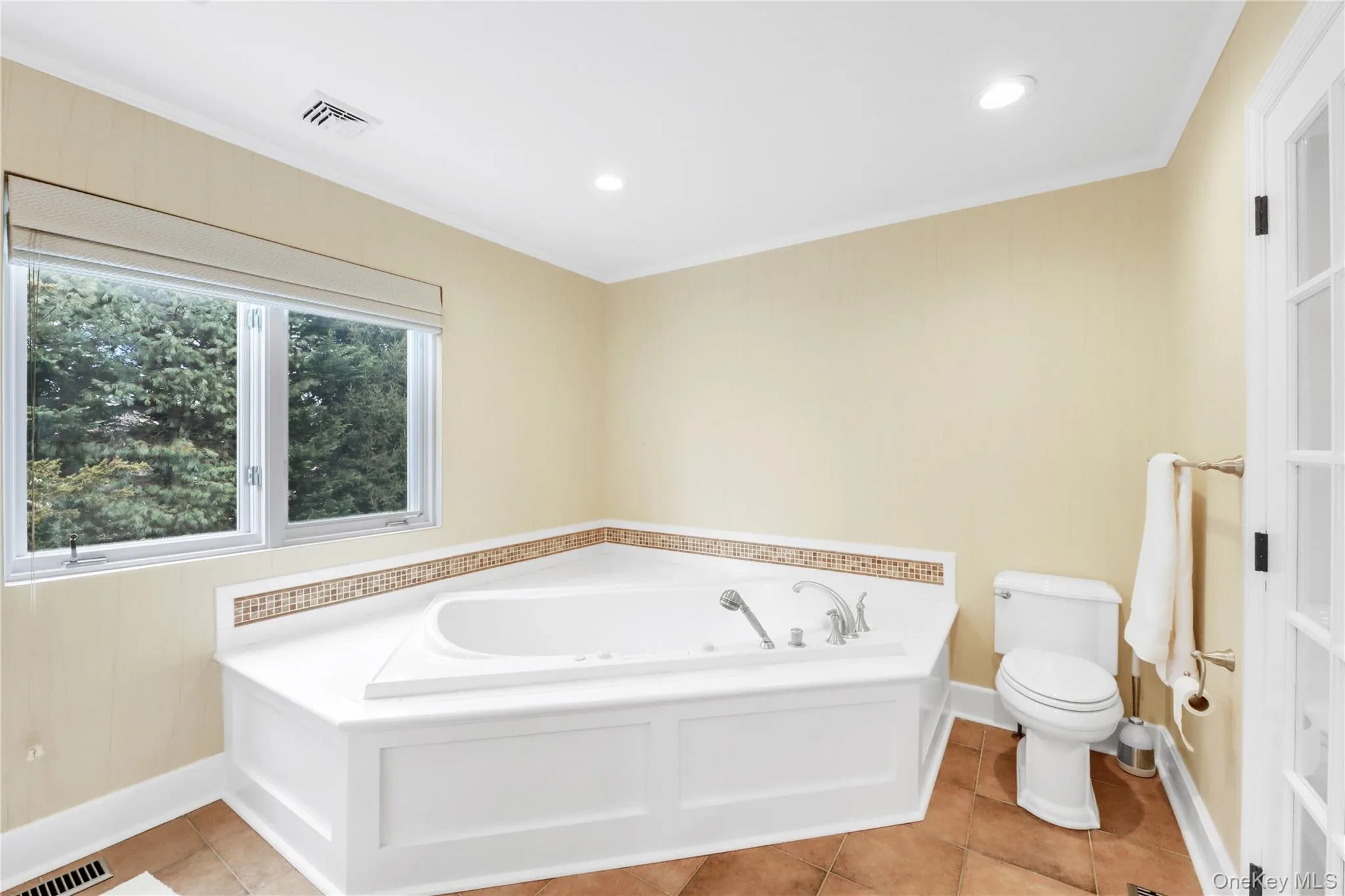 Bathroom with a bath, crown molding, light tile patterned floors, and recessed lighting Bathroom with a bath, crown molding, light tile patterned floors, and recessed lighting