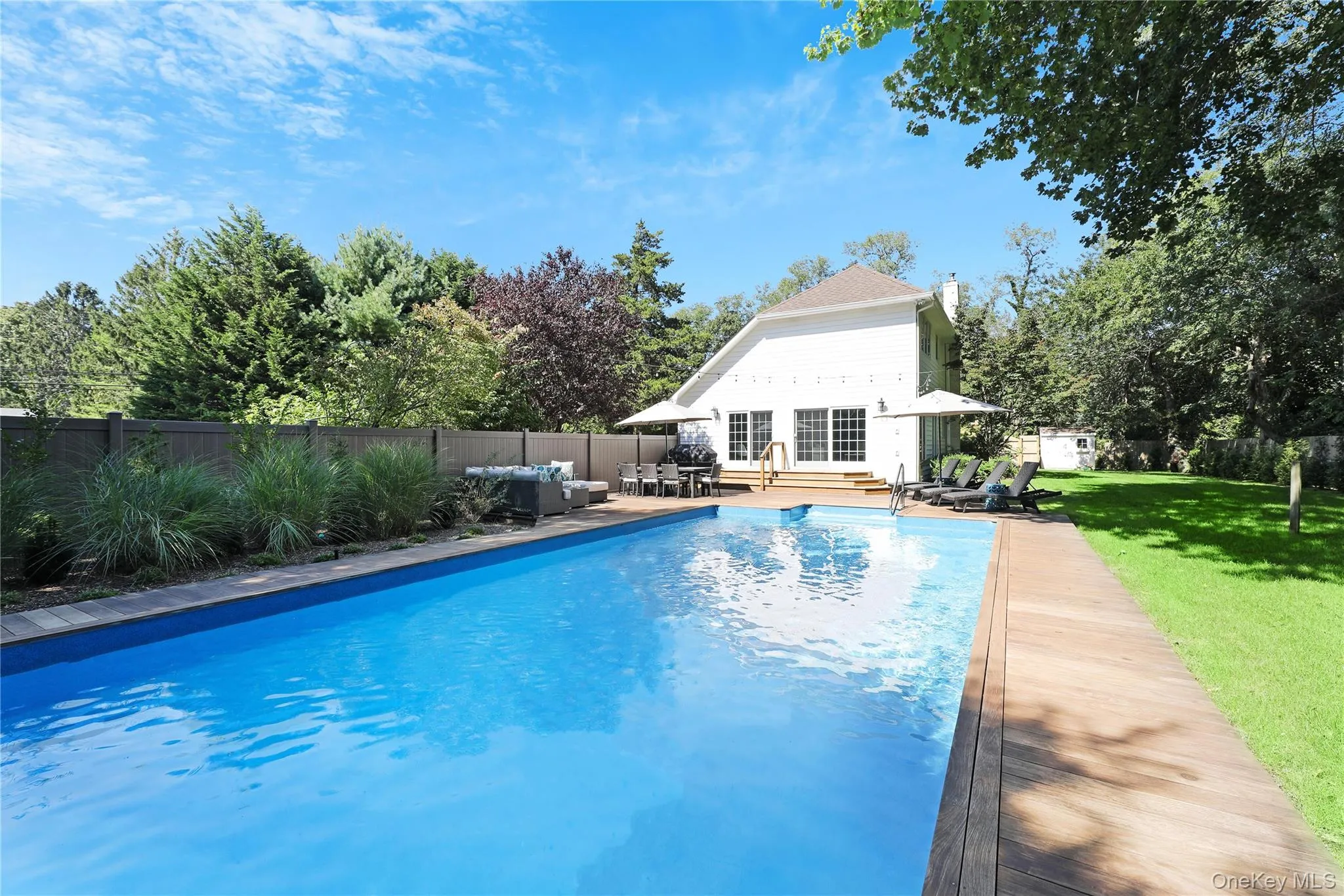 View of pool with an outbuilding, a patio, a fenced backyard, view of scattered trees, and an outdoor hangout area View of pool with an outbuilding, a patio, a fenced backyard, view of scattered trees, and an outdoor hangout area