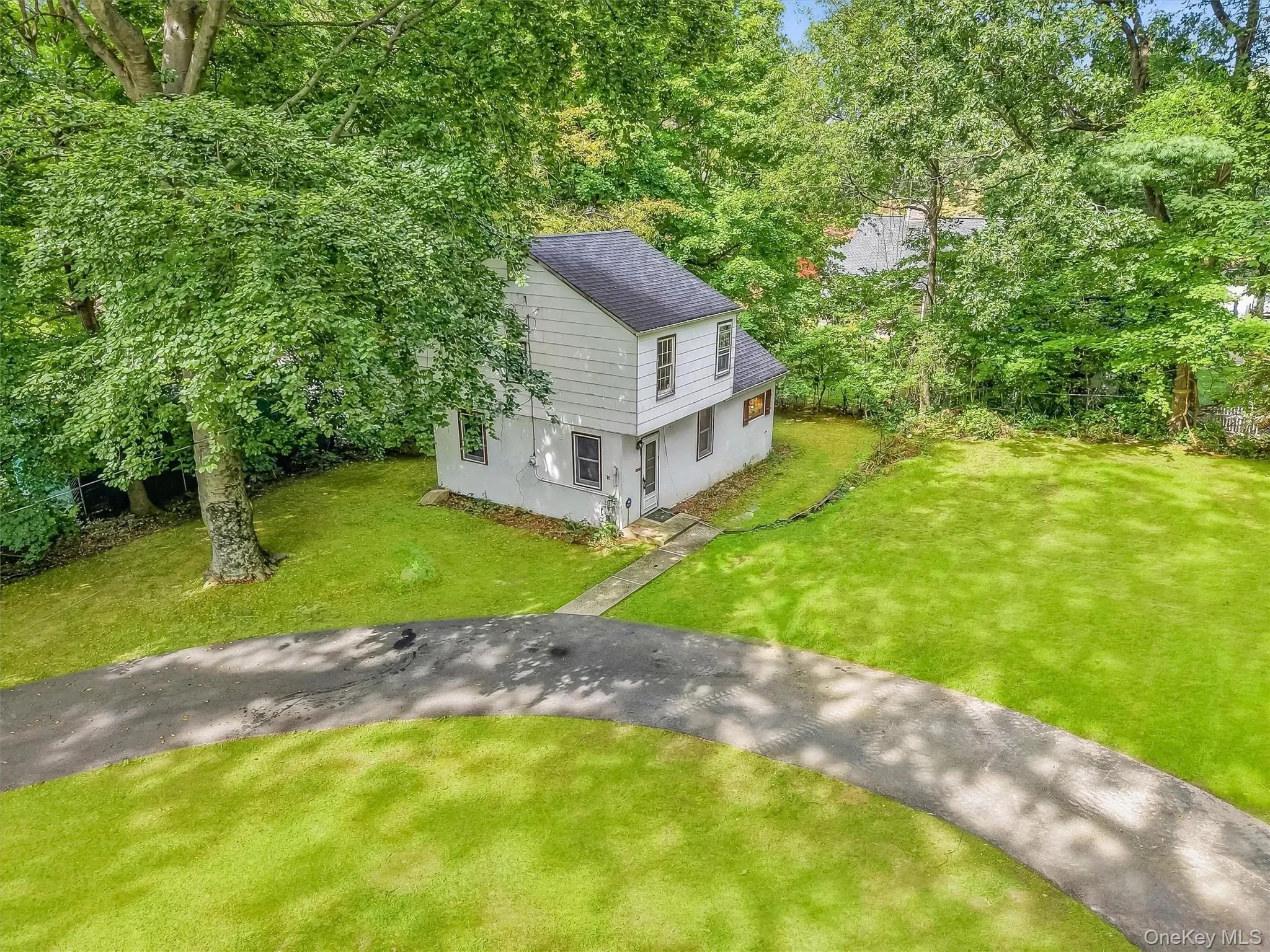 Two-story residence with white siding circular driveway Two-story residence with white siding circular driveway