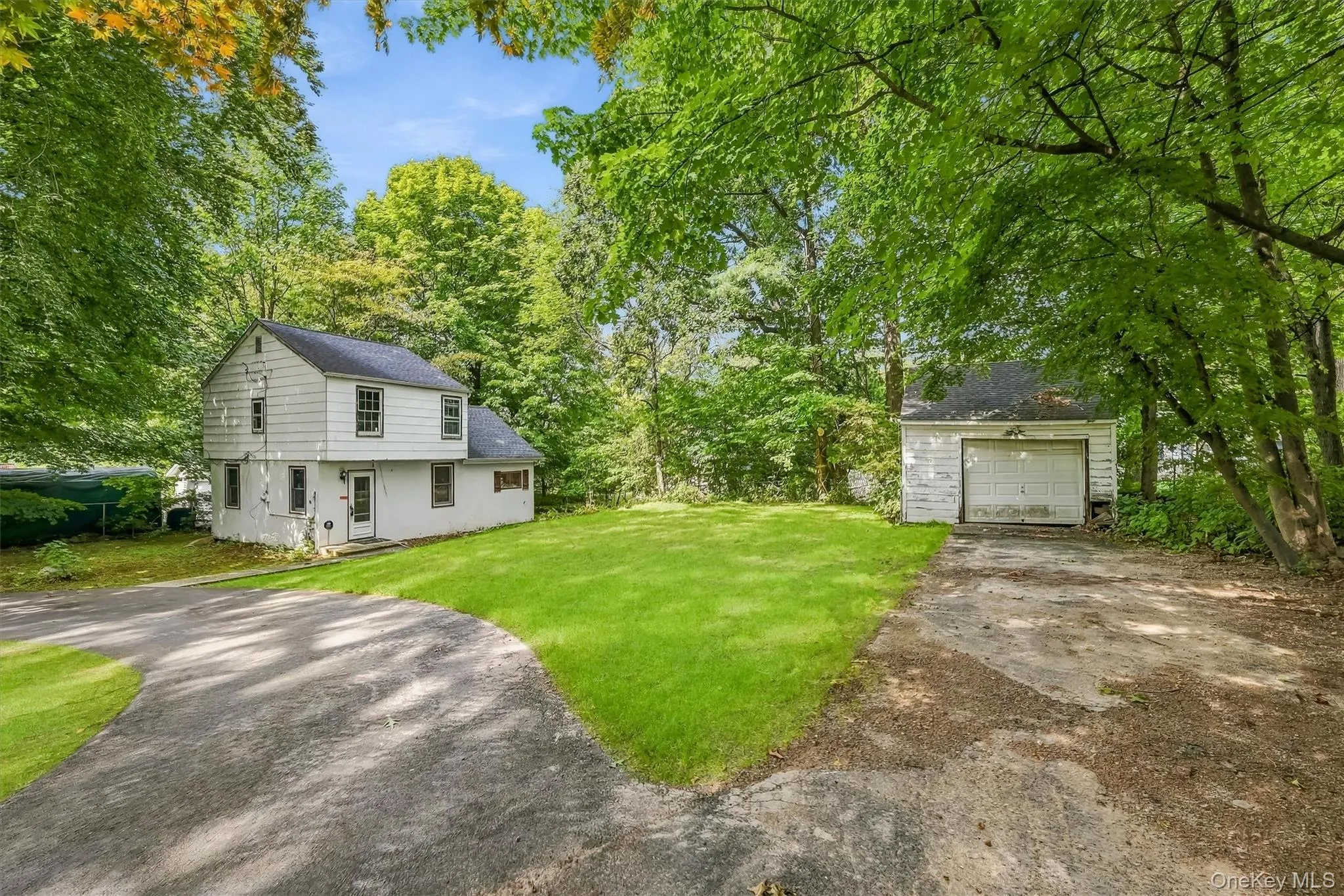 Two-story residence with white siding and dark trim windows, garage Two-story residence with white siding and dark trim windows, garage