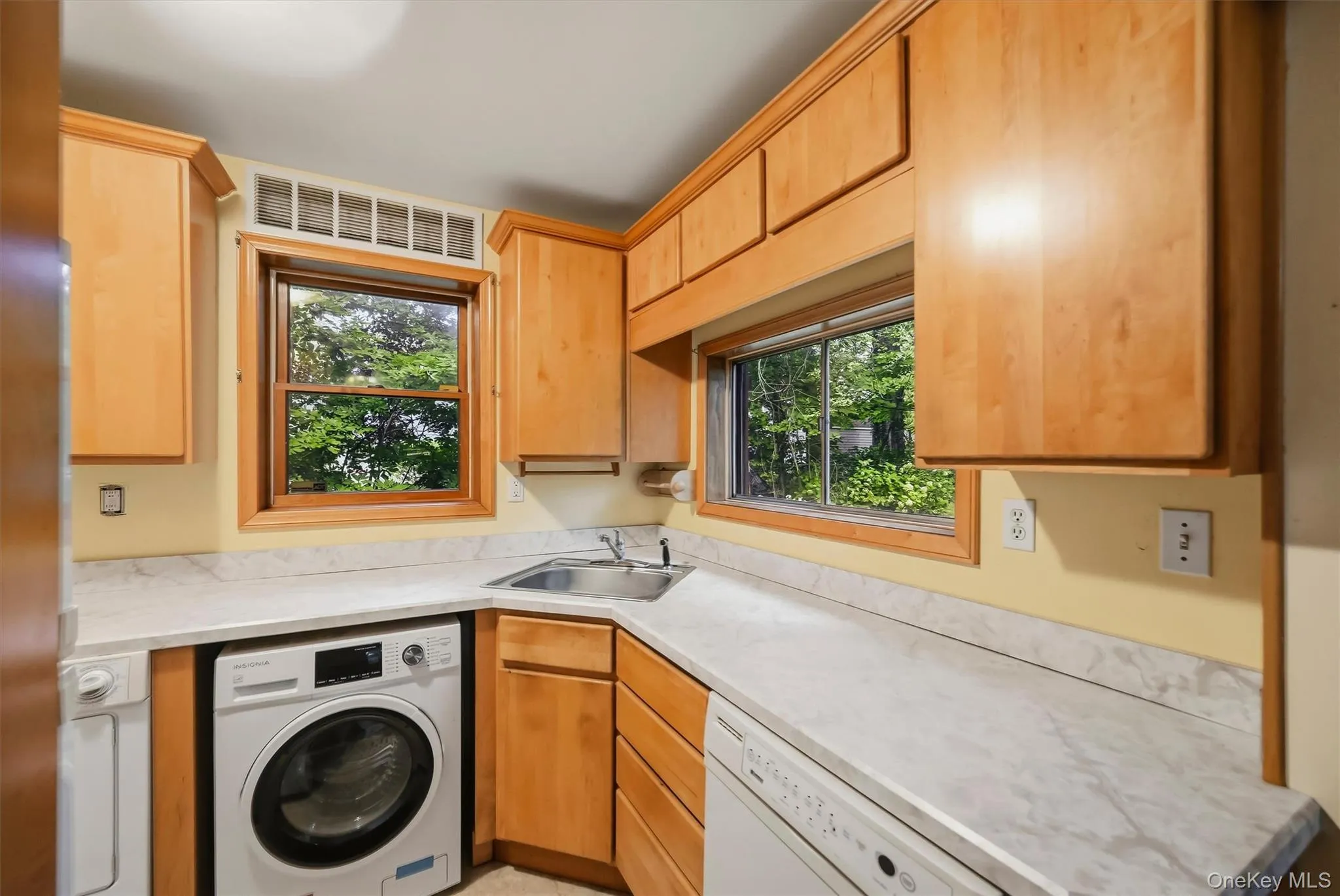 Wood-finish cabinetry paired with light-toned countertops Wood-finish cabinetry paired with light-toned countertops