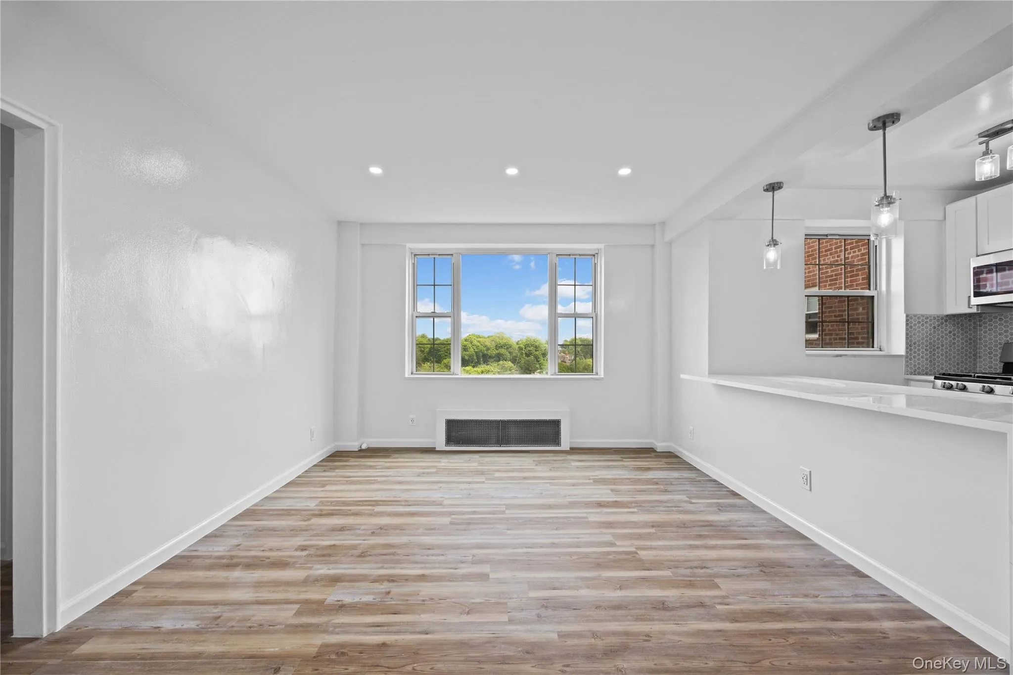 Unfurnished living room featuring a fireplace, light wood finished floors, and recessed lighting Unfurnished living room featuring a fireplace, light wood finished floors, and recessed lighting