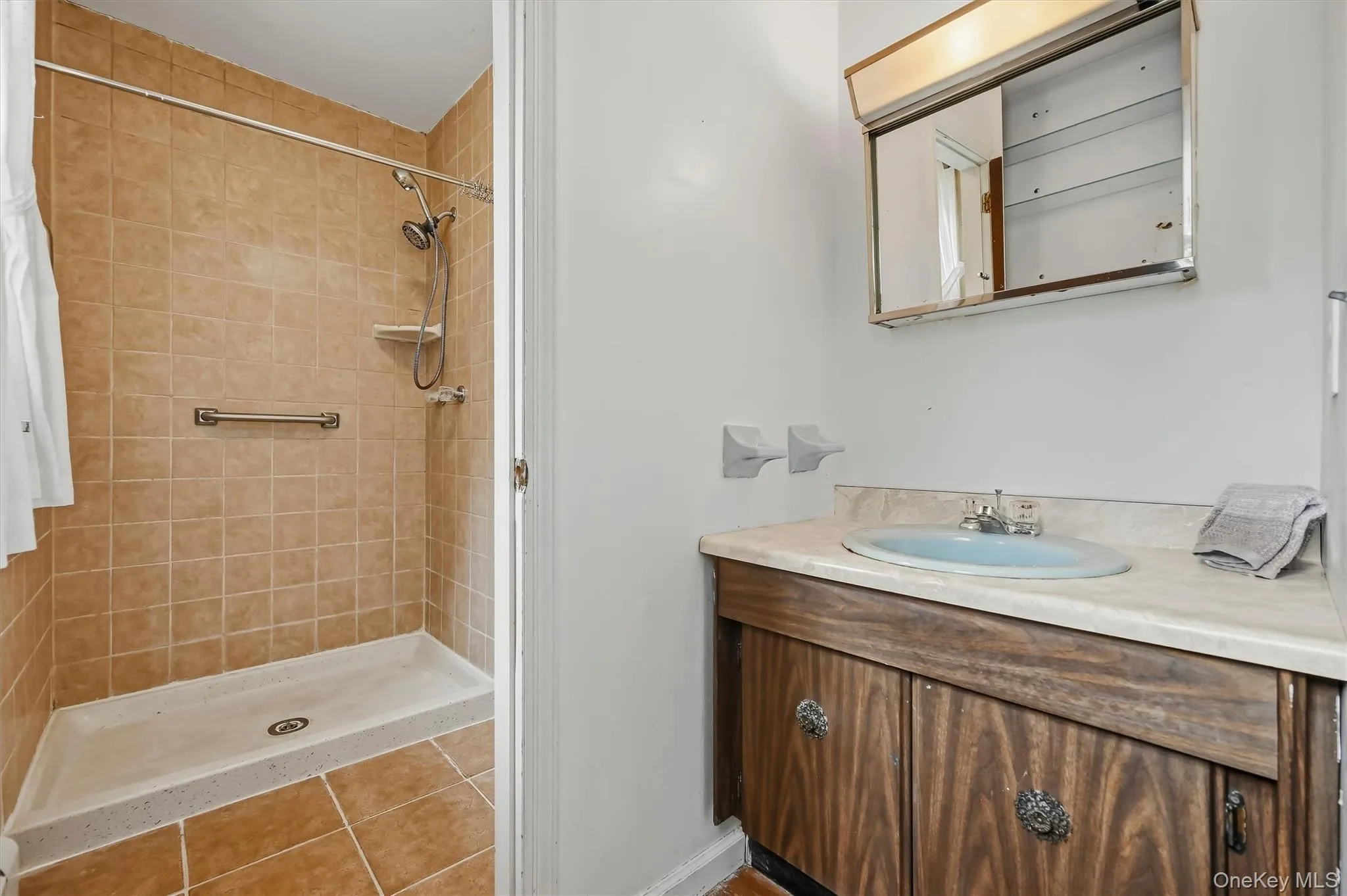 Tiled primary bath with walk-in shower and separate sink Tiled primary bath with walk-in shower and separate sink