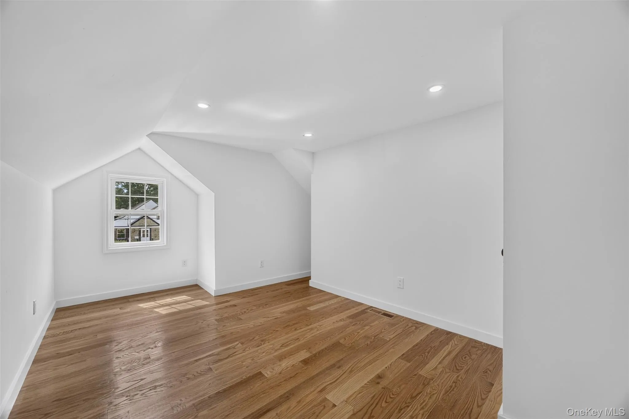 Room featuring wood-finish flooring and recessed lighting Room featuring wood-finish flooring and recessed lighting