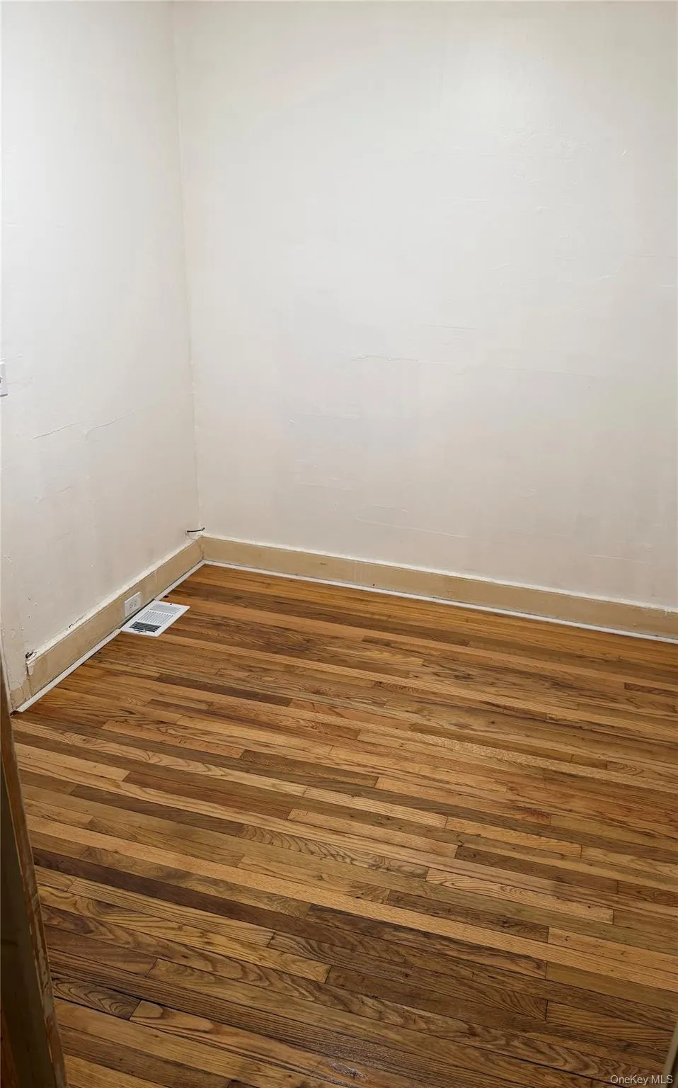 Spare room featuring hardwood / wood-style floors and baseboards Spare room featuring hardwood / wood-style floors and baseboards