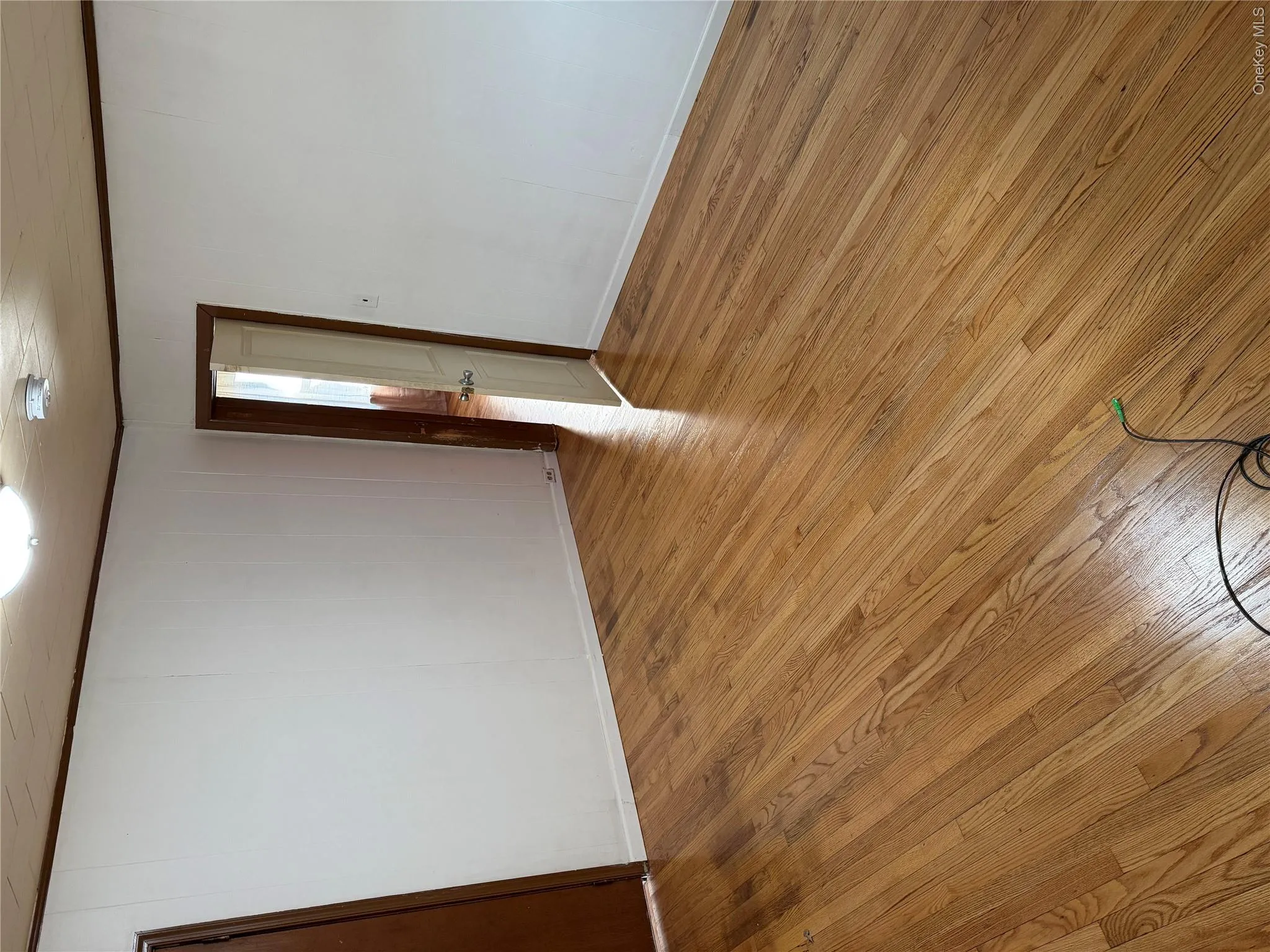 Unfurnished room featuring light wood-style flooring, crown molding, and wooden walls Unfurnished room featuring light wood-style flooring, crown molding, and wooden walls