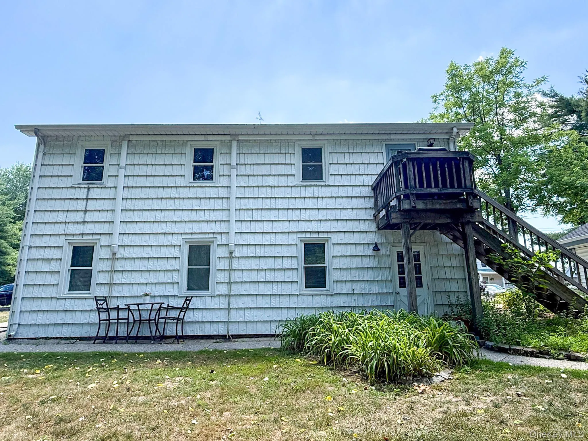 Two-story structure in back of main house. An upper-level wood deck with stairs leading to upper apartment Two-story structure in back of main house. An upper-level wood deck with stairs leading to upper apartment