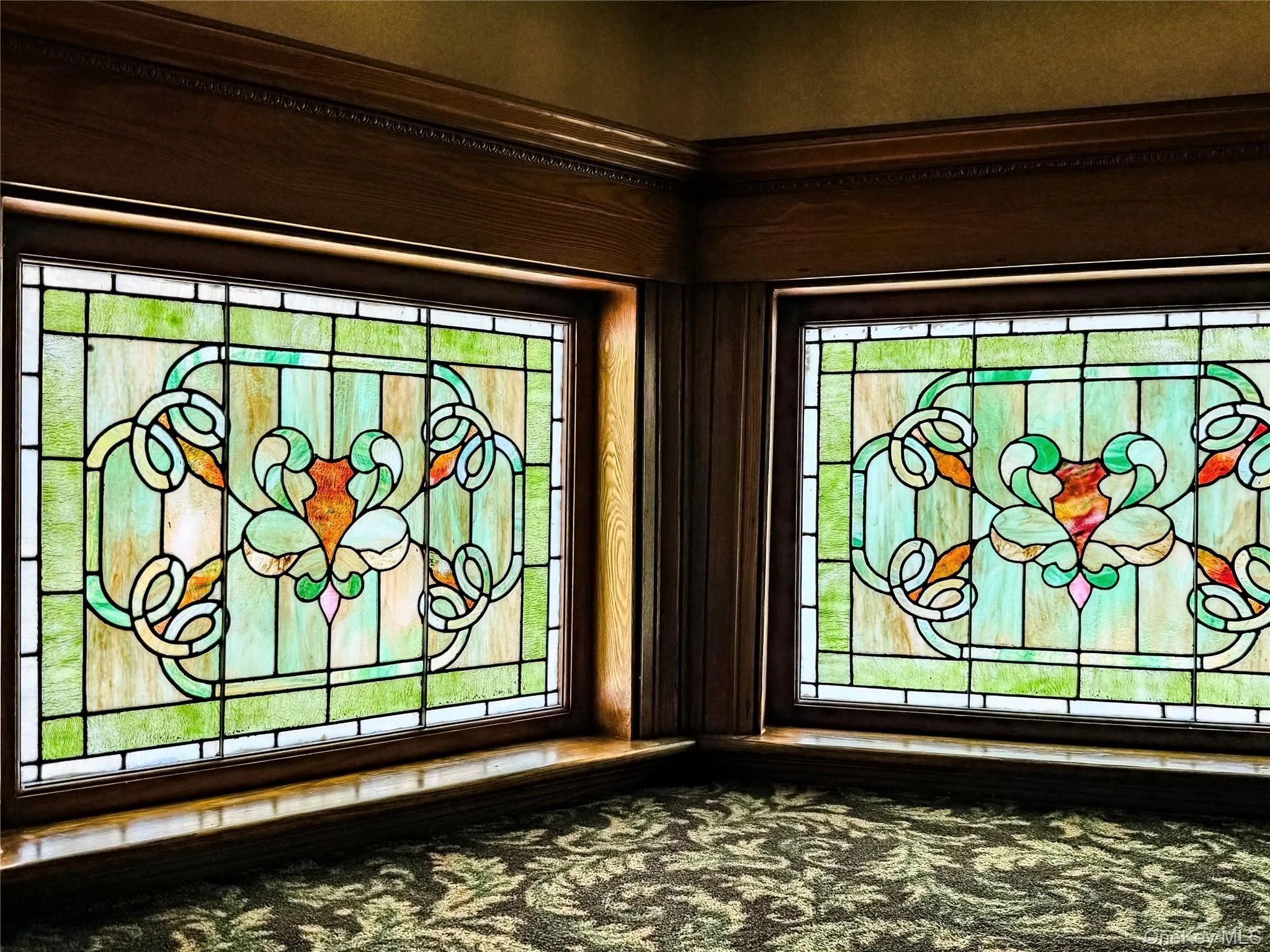 Three Story Stair Well Stained glass windows with intricate patterns, framed by rich wood millwork and crown molding Three Story Stair Well Stained glass windows with intricate patterns, framed by rich wood millwork and crown molding