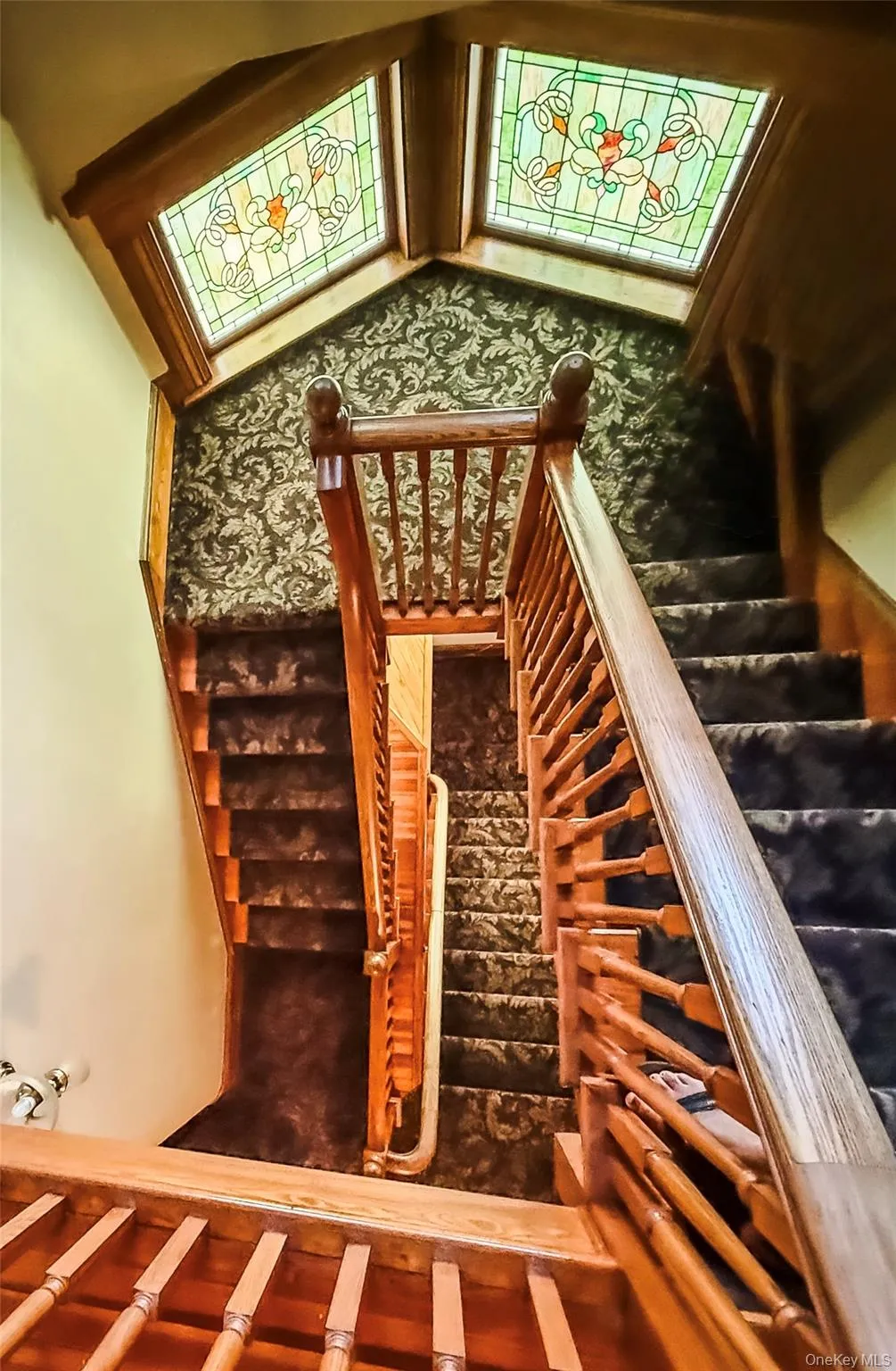 Staircase with wood banisters and balusters, carpeted tread and Stained glass windows Staircase with wood banisters and balusters, carpeted tread and Stained glass windows