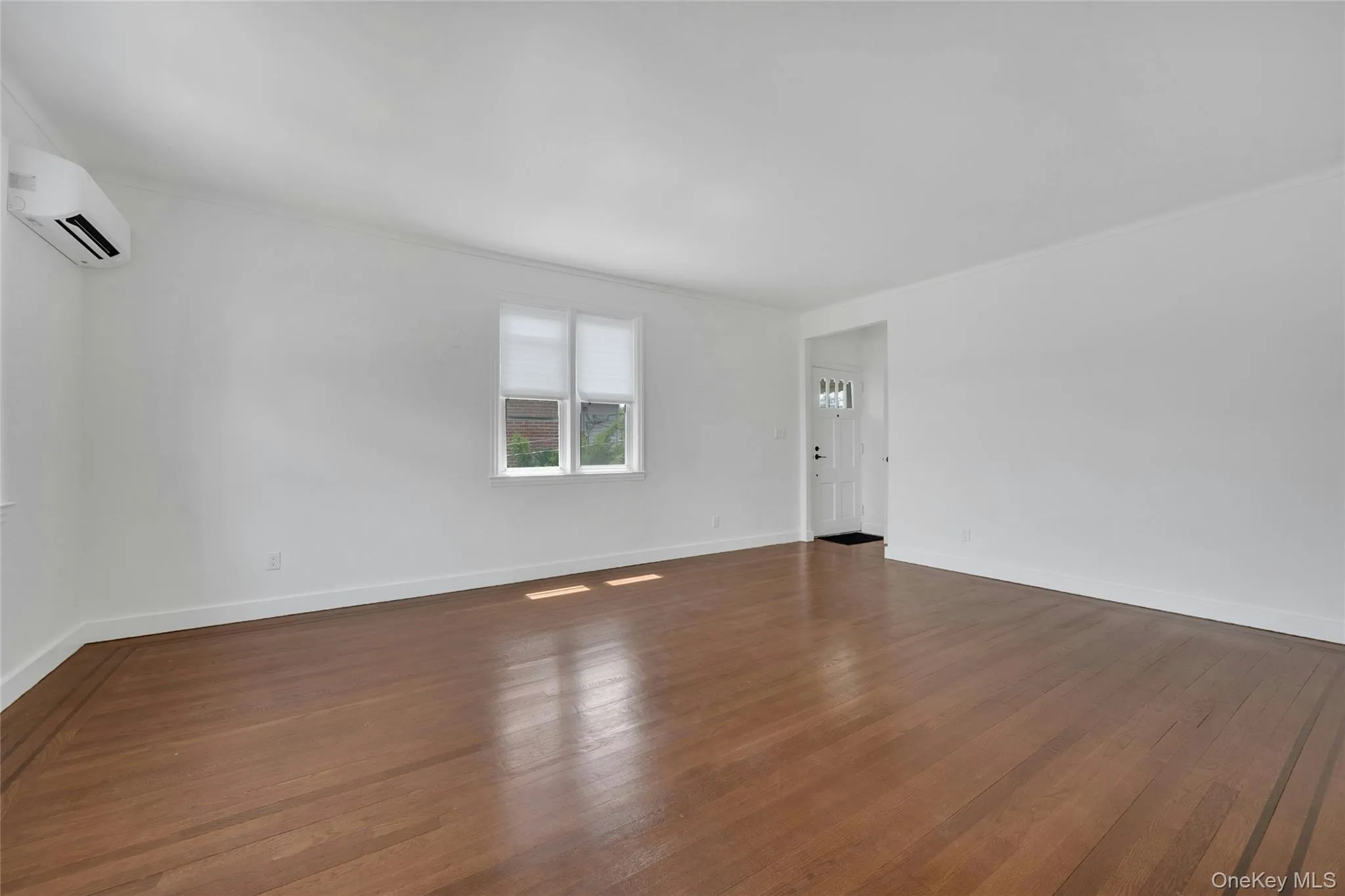 Spacious living room with split central a/c system and beautiful hardwood floors throughout. Spacious living room with split central a/c system and beautiful hardwood floors throughout.