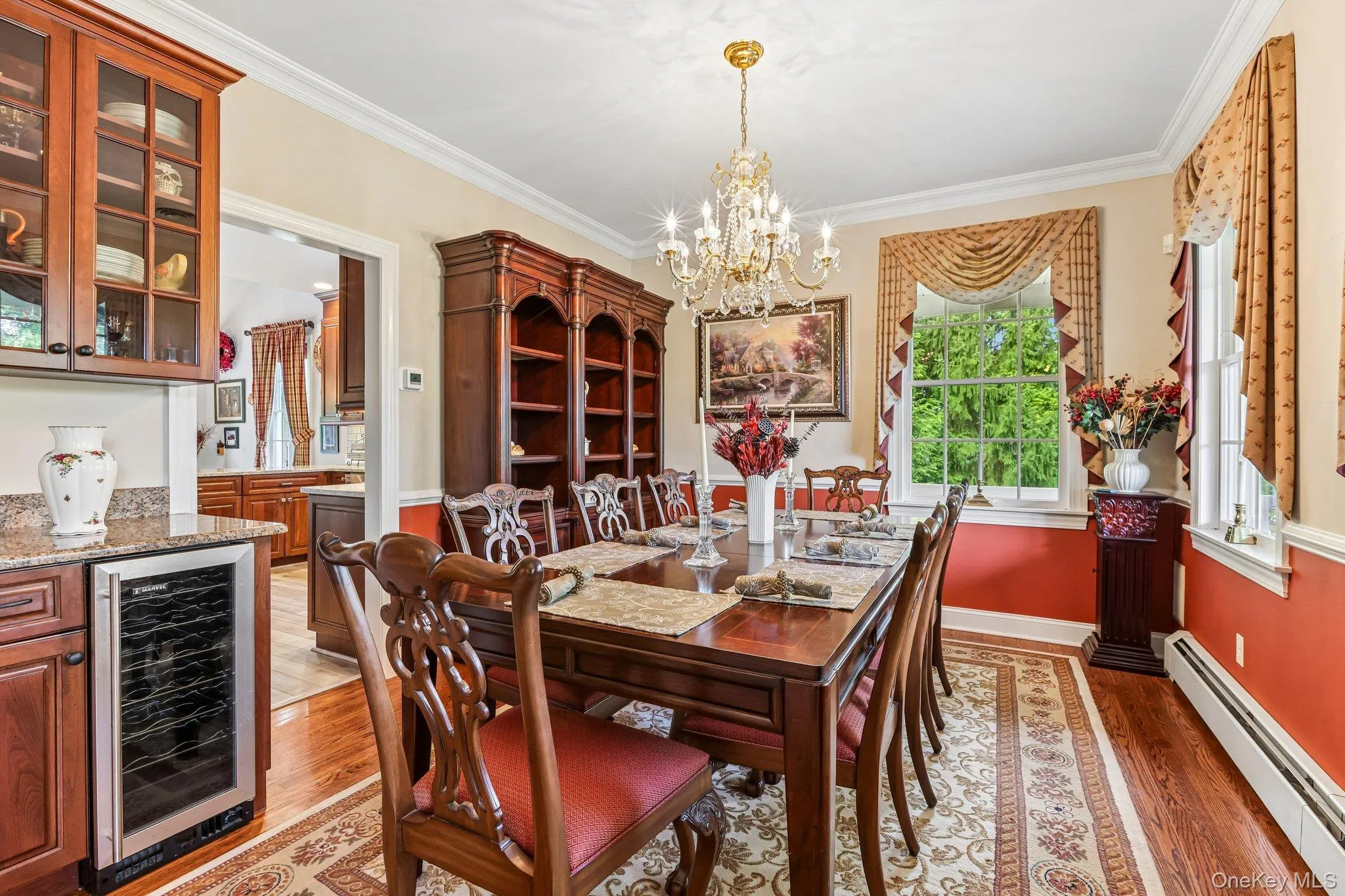 Built-in wine refrigerator, wood-finish flooring, crown molding, and a chandelier Built-in wine refrigerator, wood-finish flooring, crown molding, and a chandelier