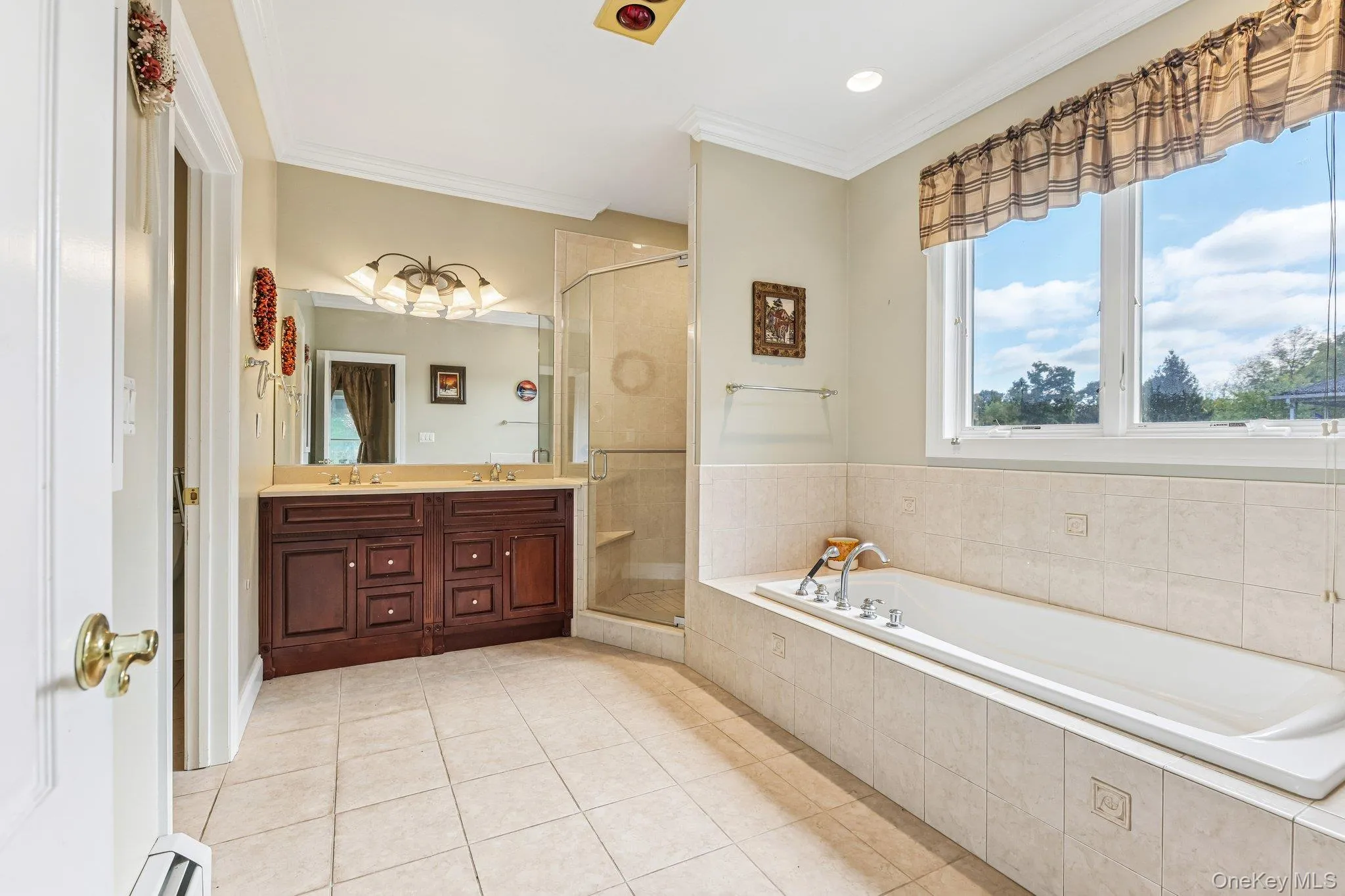 Dual vanity with integrated sinks, a built-in soaking tub, and a glass-enclosed shower Dual vanity with integrated sinks, a built-in soaking tub, and a glass-enclosed shower