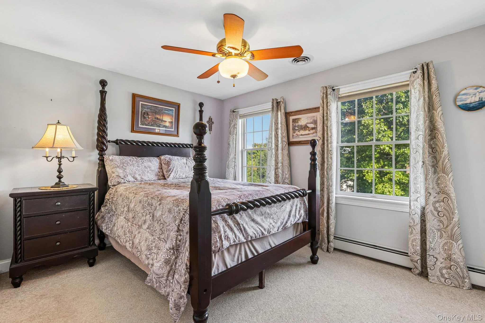 Carpeted bedroom with two large windows, a ceiling fan, and light gray wall paint Carpeted bedroom with two large windows, a ceiling fan, and light gray wall paint