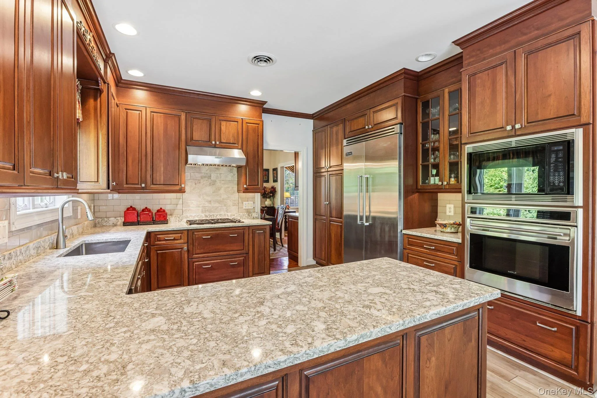 Kitchen featuring wood cabinetry, light-toned countertops, stainless steel appliances, and recessed lighting Kitchen featuring wood cabinetry, light-toned countertops, stainless steel appliances, and recessed lighting