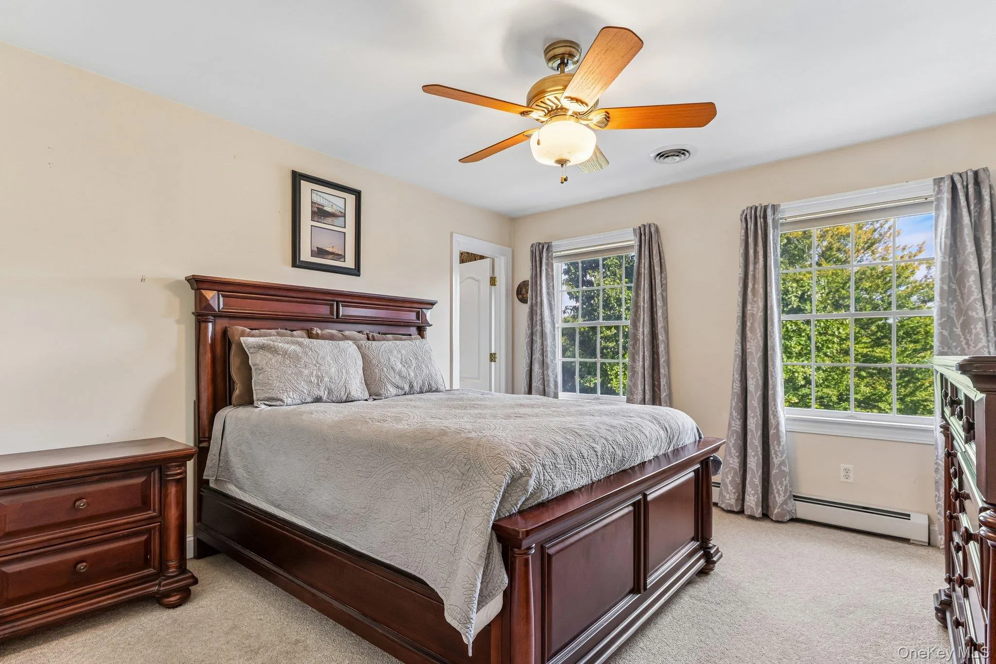Wall-to-wall carpeting, two large windows, and a ceiling fan with integrated lighting Wall-to-wall carpeting, two large windows, and a ceiling fan with integrated lighting